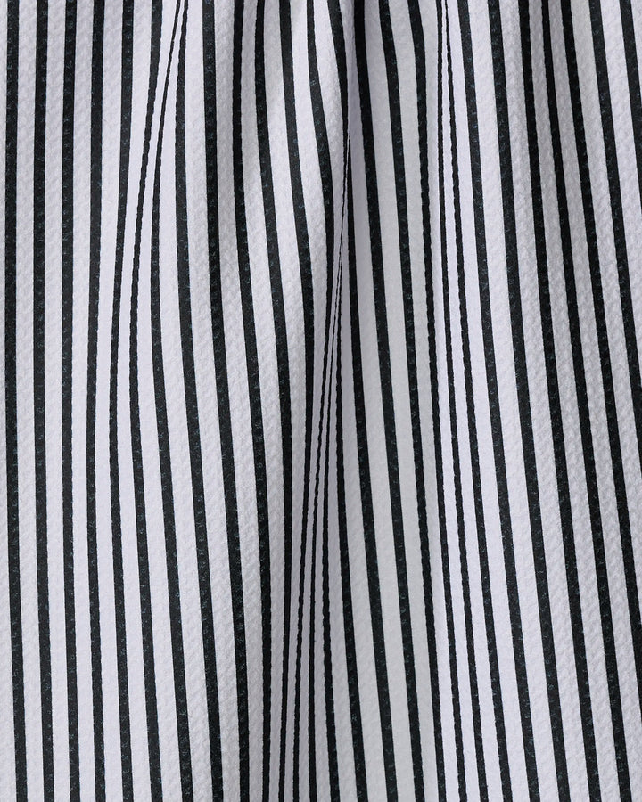 Close-up of the Love Notes tea towel by Kailee Wright, featuring black and white vertical stripes. Made from recycled materials, the fabric is gently draped, creating soft folds and shadows between the stripes.