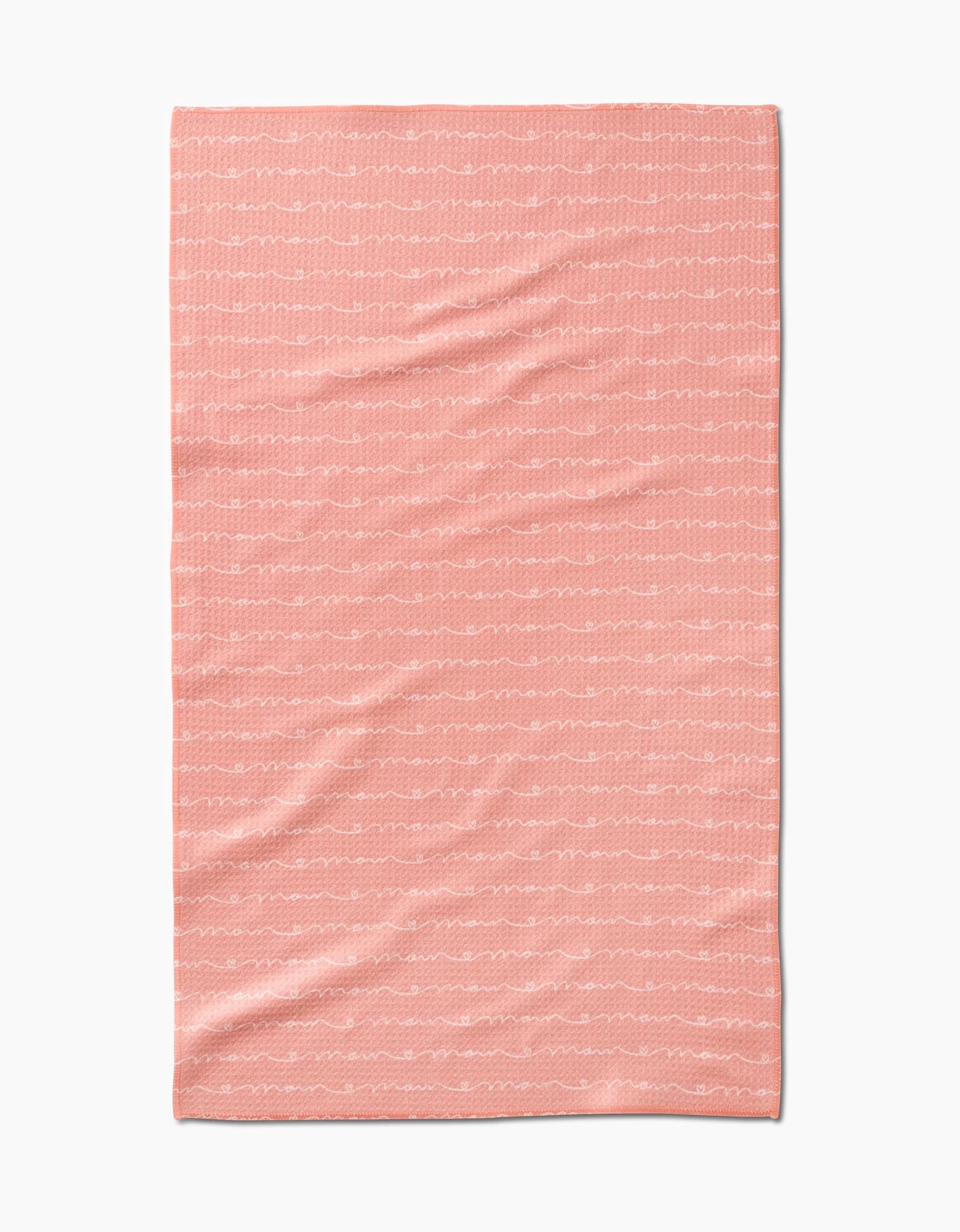The Love of Mom blanket by Sarah Reed is a soft pink throw made from recycled materials, with thin, wavy white lines running horizontally, shown flat on a white background.