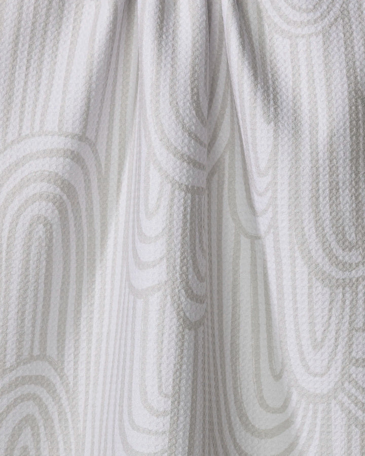 A close-up of the Lovers Arc tea towel by Hufton Studio, featuring a white textured fabric with a subtle light gray geometric pattern. The soft draping and gentle folds highlight its elegant design.