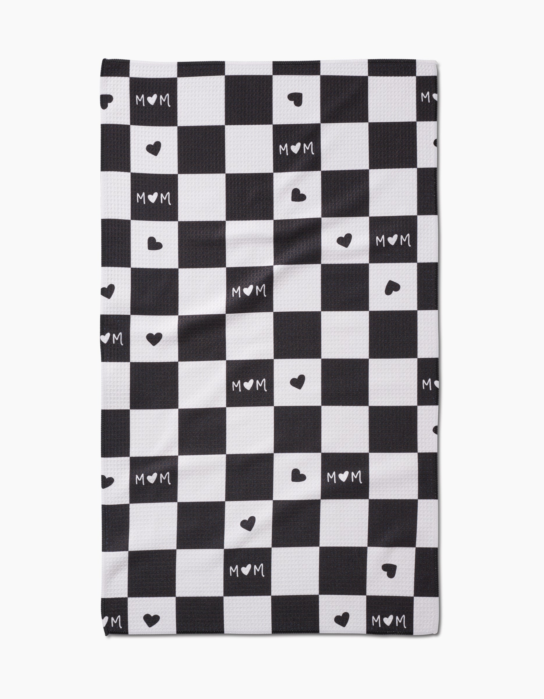 The GEOMETRY Loving Tea Towel features a black and white checkered pattern with MOM and small hearts in some white squares, crafted from soft Geoweave fabric.