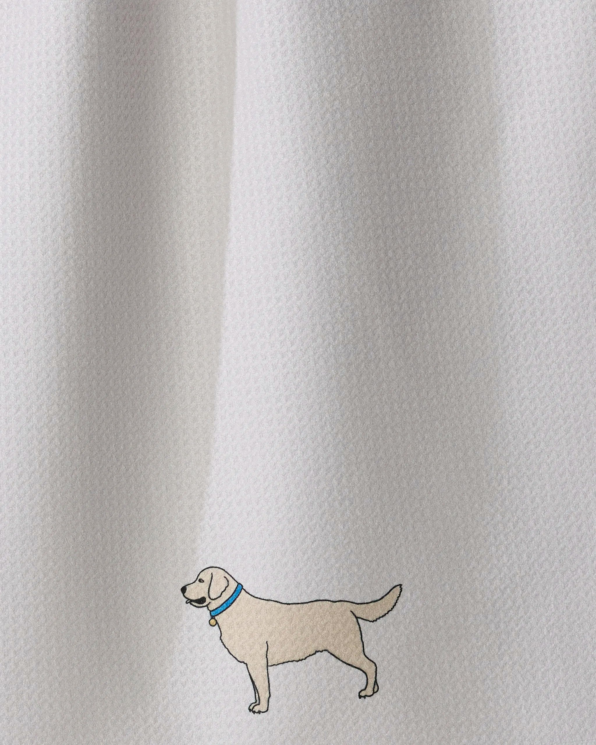 Centered near the bottom of a textured white background, a simple illustration of a light-colored dog wearing a blue collar gives the Geometry “Loyal Lab” ultra-absorbent tea towel a playful yet practical touch for any kitchen.