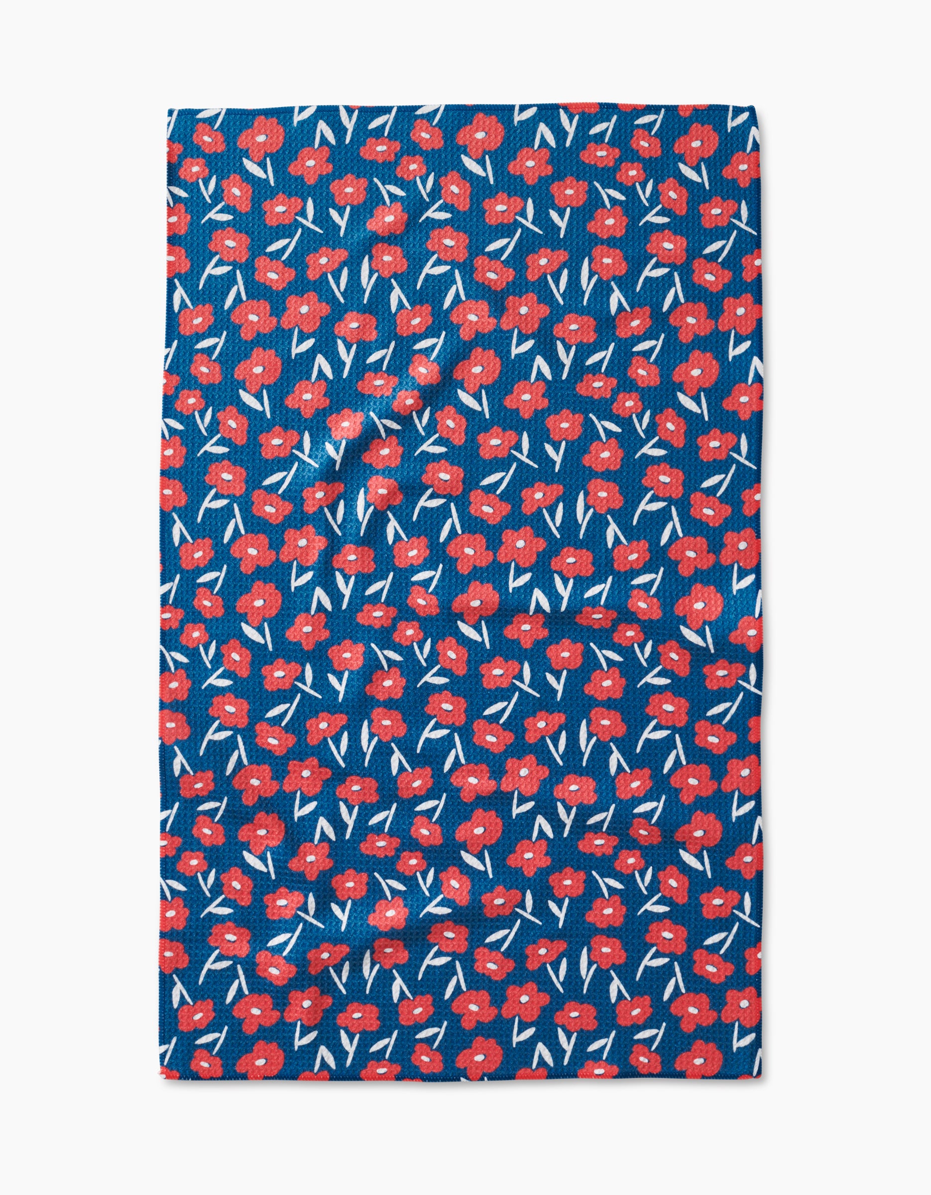 The Luca Daisy Red tea towel by Hufton Studio features a blue background with small red flowers, white accents, and green stems in a repeating pattern, made from recycled materials.