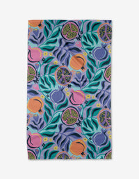 The Lucky Pomegranate tea towel by Masha Volnova is a rectangular, ultra-absorbent towel featuring an abstract fruit and leaf pattern with colorful accents on a light blue background.