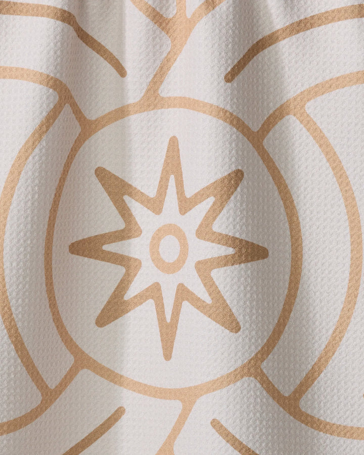 The Lunar tea towel by Adam Nienow features a central eight-pointed star within a circle and radiating curves on textured white fabric, adding elegance and absorbency to your kitchen.