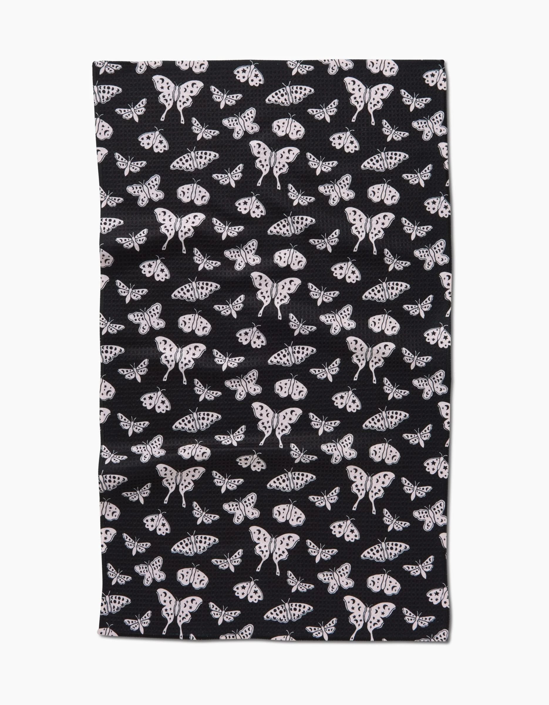 The Kayla Ann Lunar Moths Black tea towel features a black background with evenly spaced, detailed white lunar moth patterns in a rectangular shape.