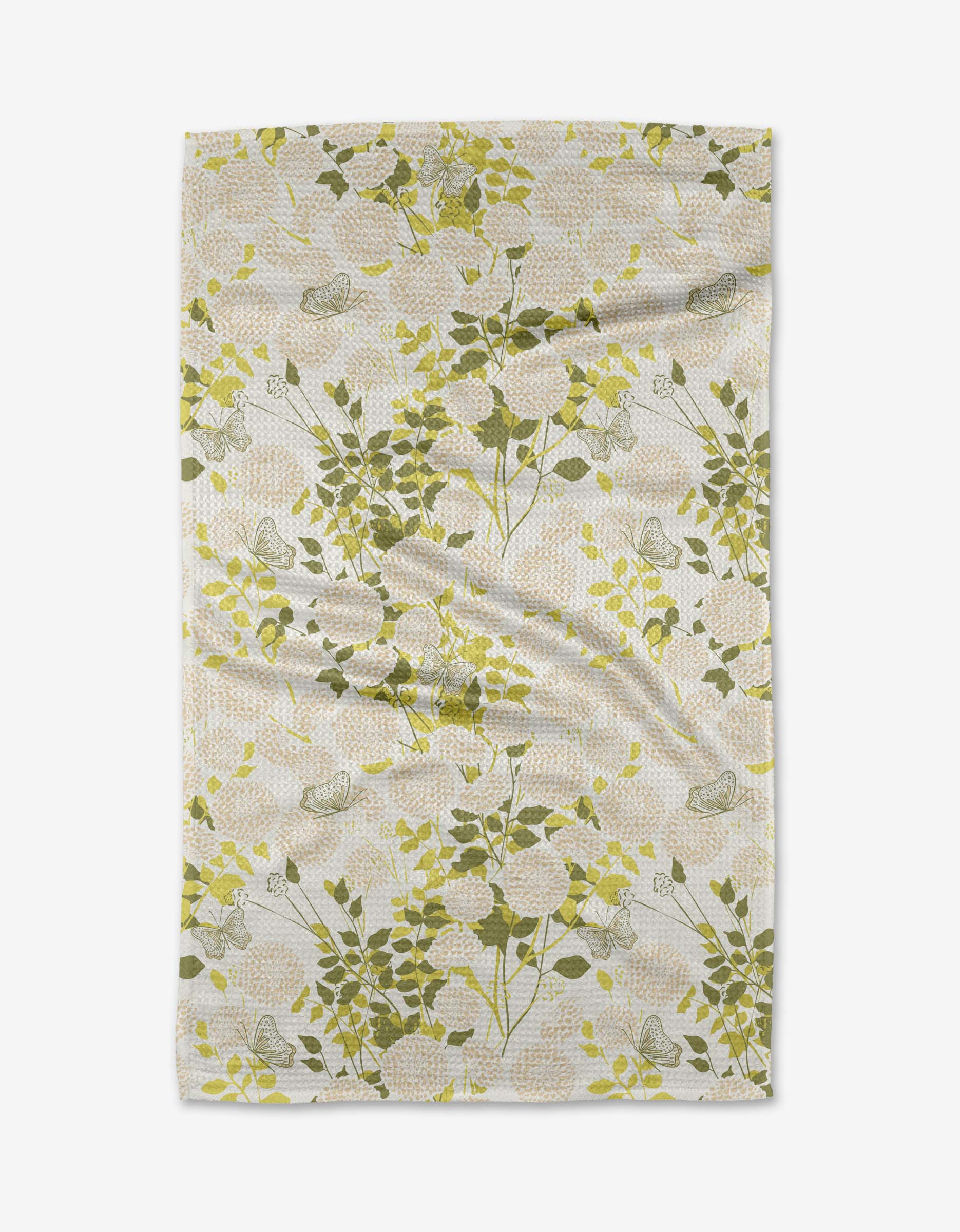 The Lush Garden tea towel from Second Nature Studio features a botanical pattern of green and yellow leaves on thin branches over a light, intricately designed background. Made from recycled materials, it showcases natural wrinkles and soft folds.