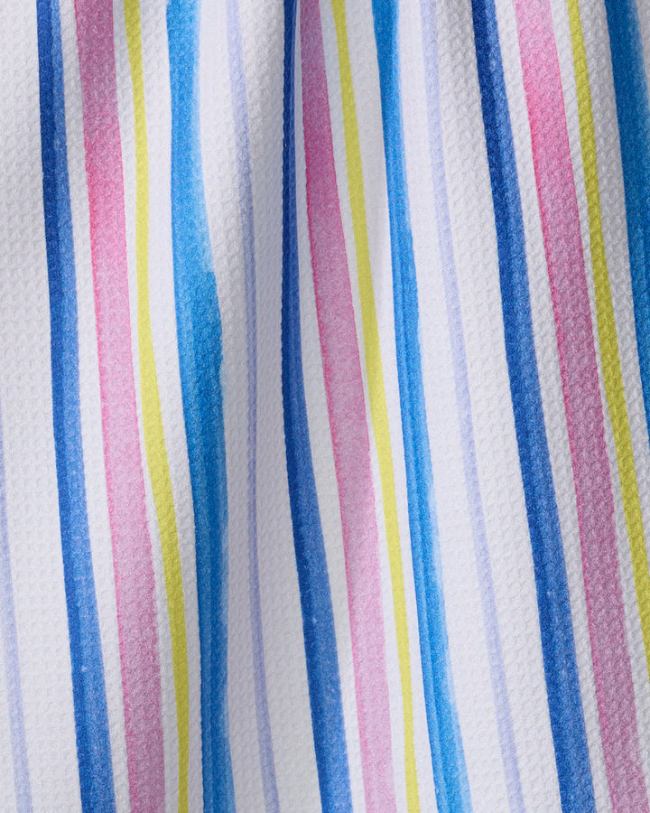 The Macarons in Paris Stripe tea towel by Travel Write Draw (Meagan Morrison) features hand-painted style blue, pink, yellow, and purple stripes on textured white fabric for a vibrant yet practical kitchen accent.