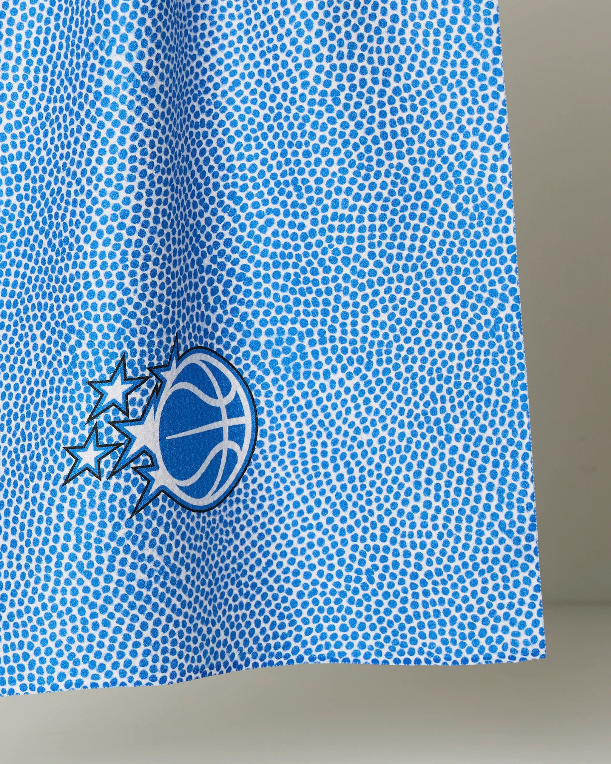 The NBALAB x Geometry Magic Grip tea towel features a blue and white basketball design with comet-like stars on a dotted background.
