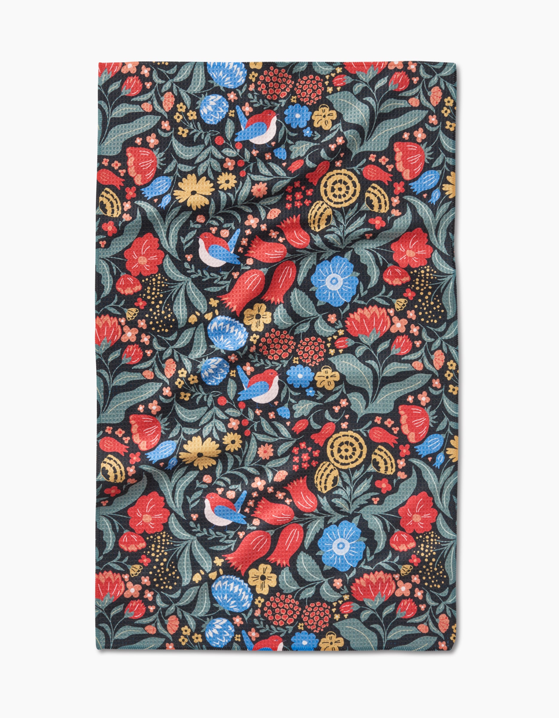 The Marsh Wren tea towel by Danelys Sidron features a vibrant floral and bird pattern with red, blue, and yellow flowers plus green leaves on a dark background, made from ultra-absorbent Geoweave fabric in a rectangular shape.