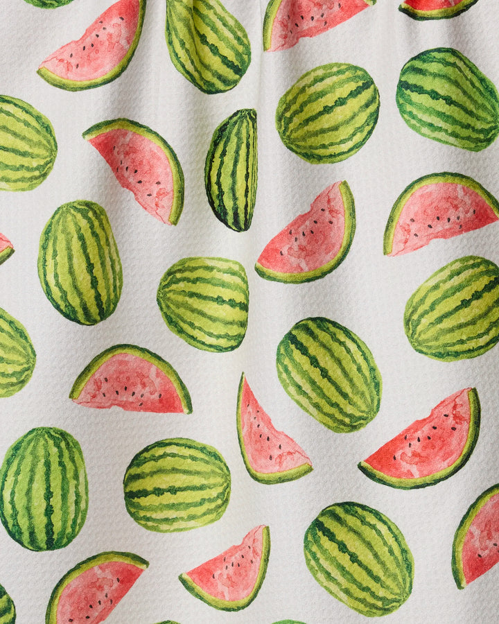 The Melon Market tea towel by Geometry features a watercolor pattern of whole and sliced watermelons, making it an eco-friendly and fresh addition to your kitchen.