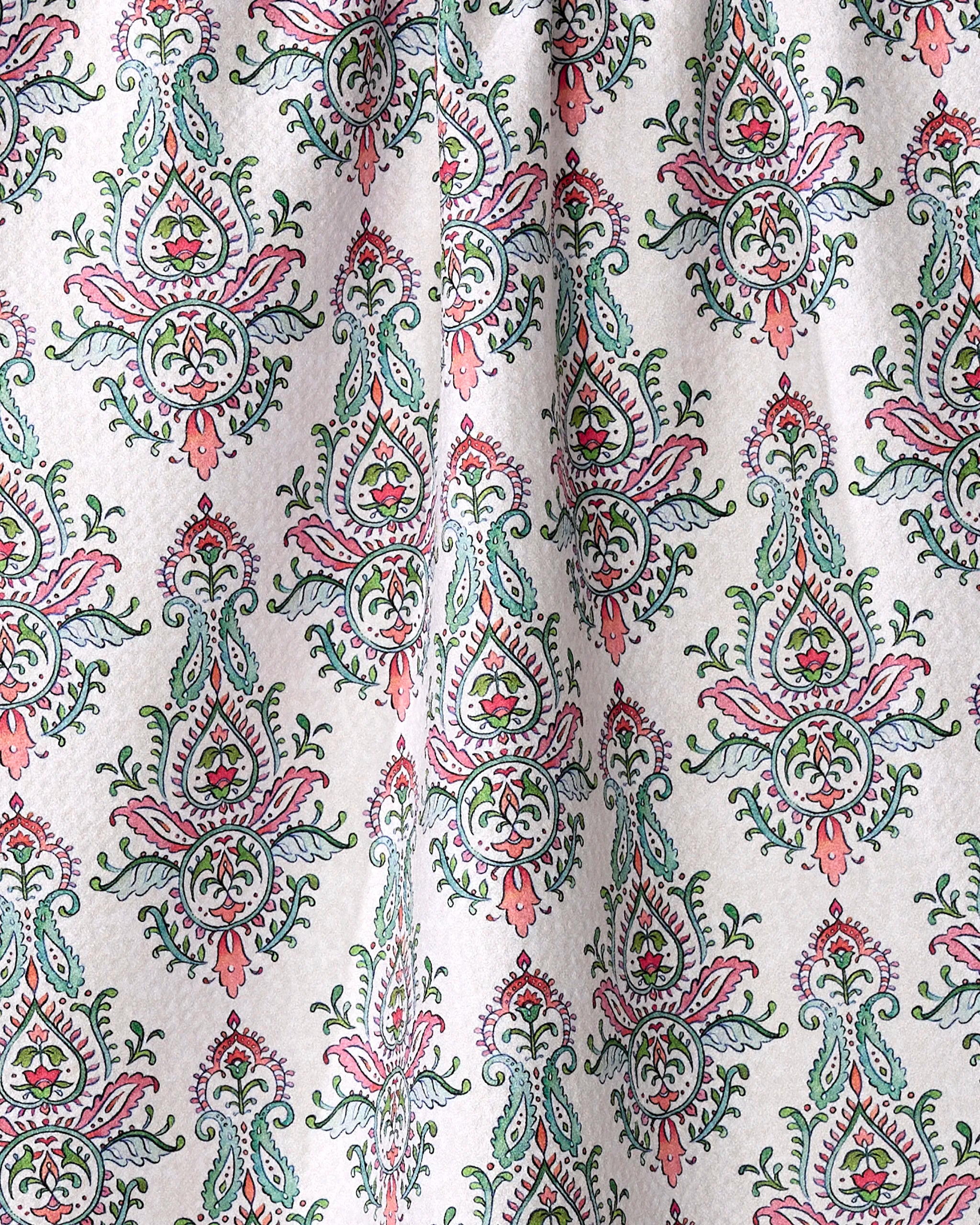 The "Memento" kitchen tea towel by Maayan Alper-Swan features white fabric with pink, green, and teal floral and paisley patterns in a diamond grid. Made from recycled materials, it showcases intricate motifs and visible folds.