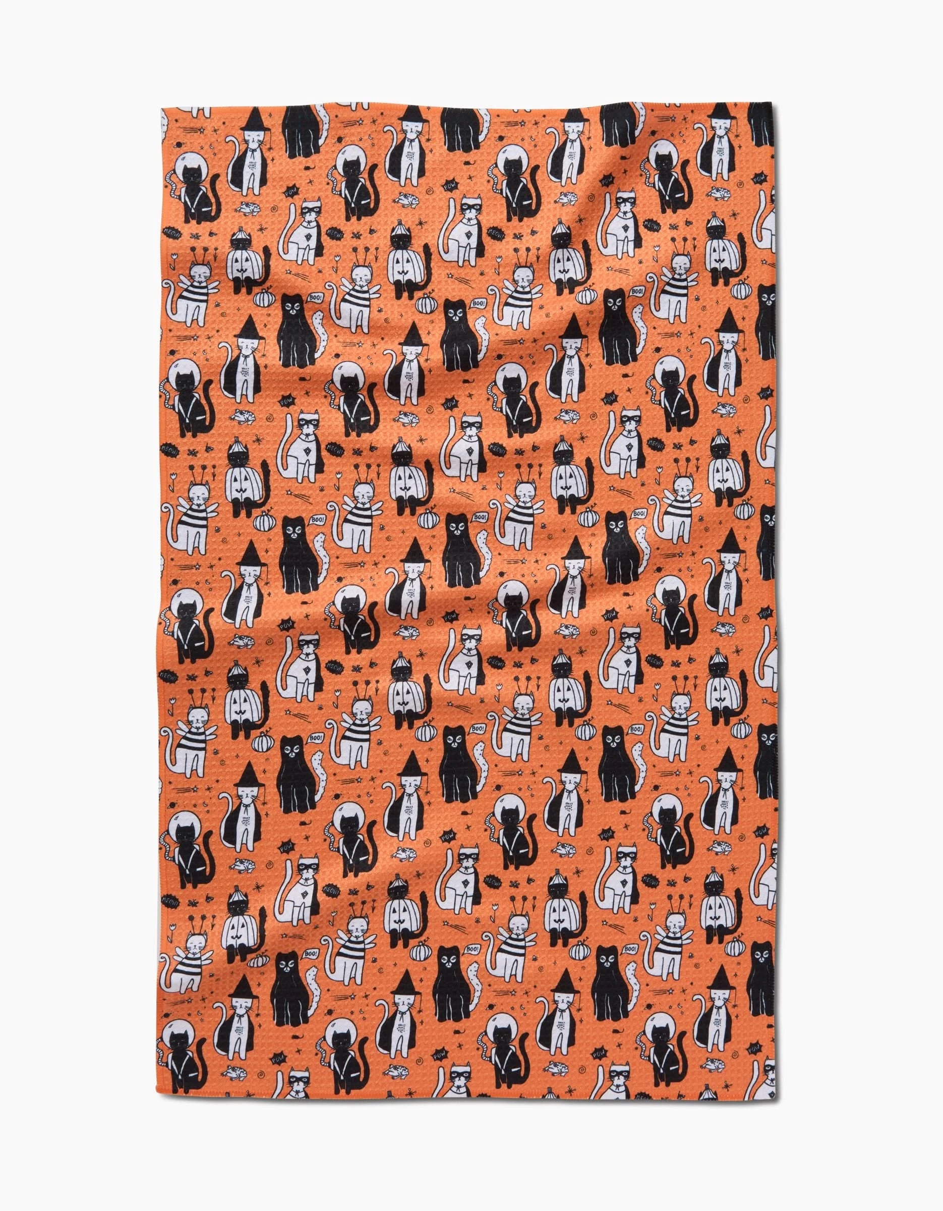 The Meowlloween blanket by Elisabeth Wing is orange, made from recycled materials, and features a playful pattern of cartoon black, white, and orange cats with paw prints and fishbones.