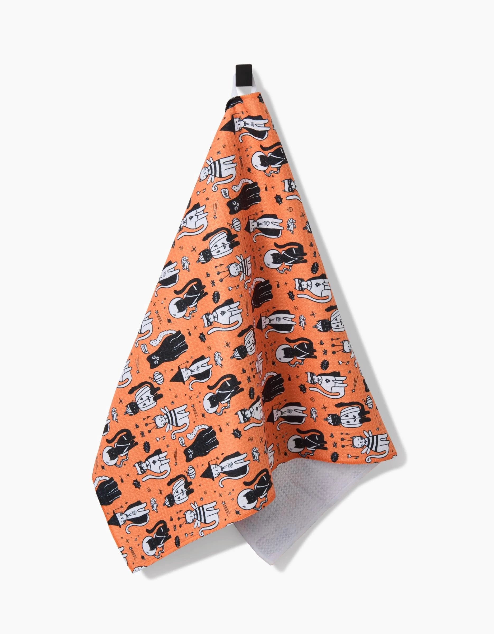 The Meowlloween tea towel by Elisabeth Wing features black and white cartoon cats in playful poses with fun shapes. Made from ultra-absorbent recycled materials, it has a black hanging loop for convenience.