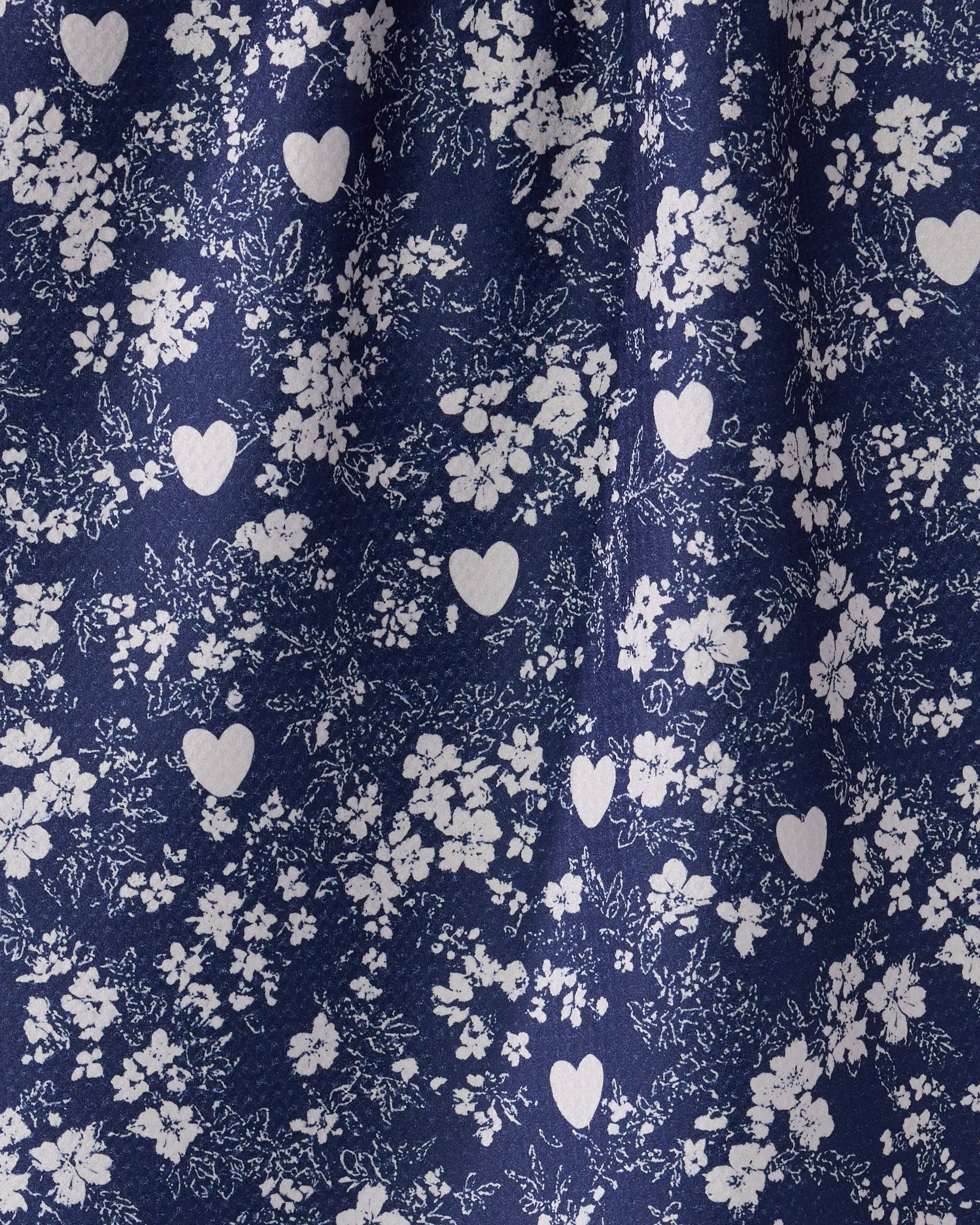 Midnight Posy by Geometry features dark blue fabric with a white floral and heart pattern. Clusters of small flowers and scattered hearts create a delicate, romantic look—perfect for an eco-friendly tea towel. Gentle fabric folds are visible.
