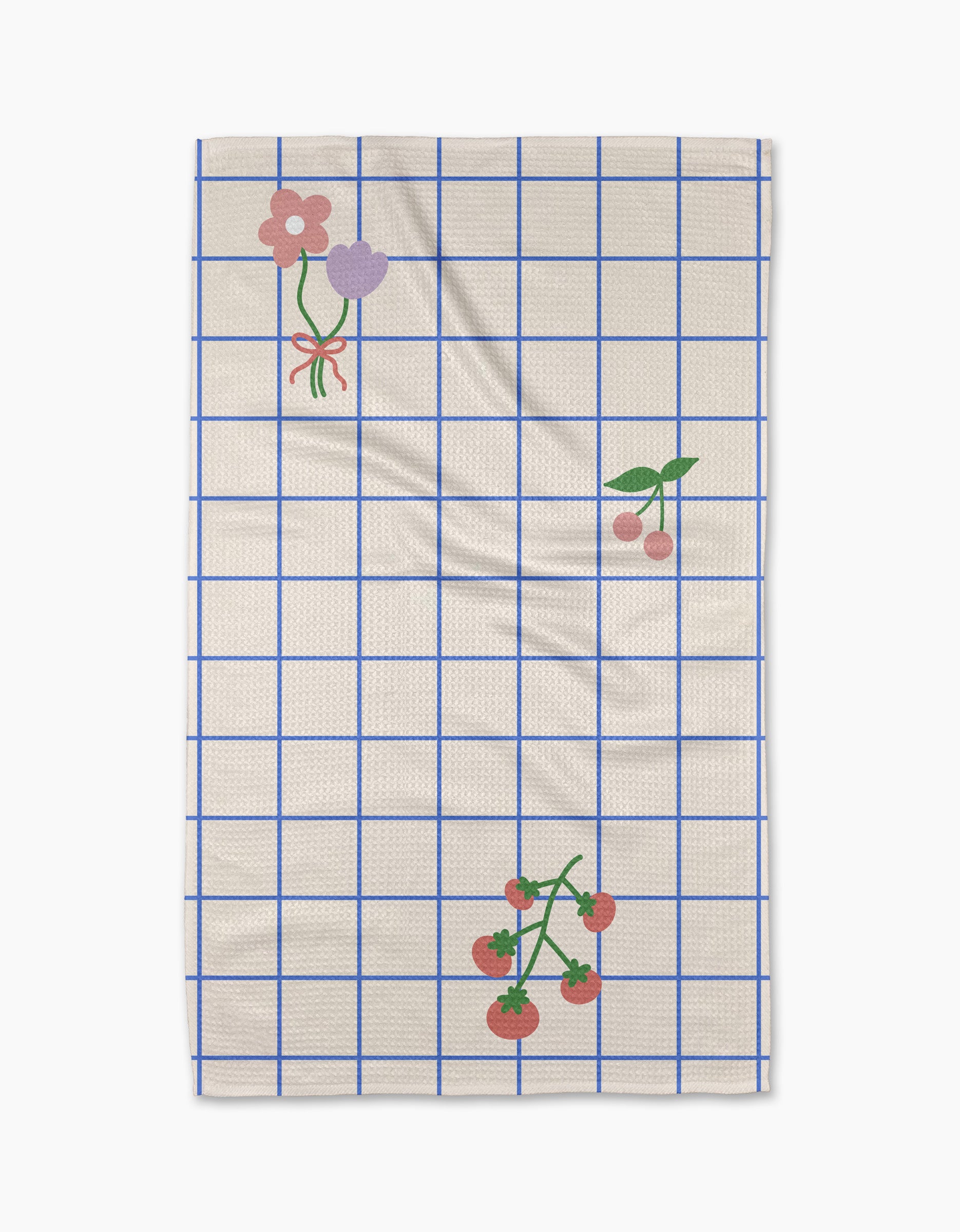 The Mini Harvest tea towel by Letters By Shells features a cream base with a blue grid, decorated with pink and purple flowers, cherries, and tomatoes—crafted from recycled materials for an eco-friendly touch.