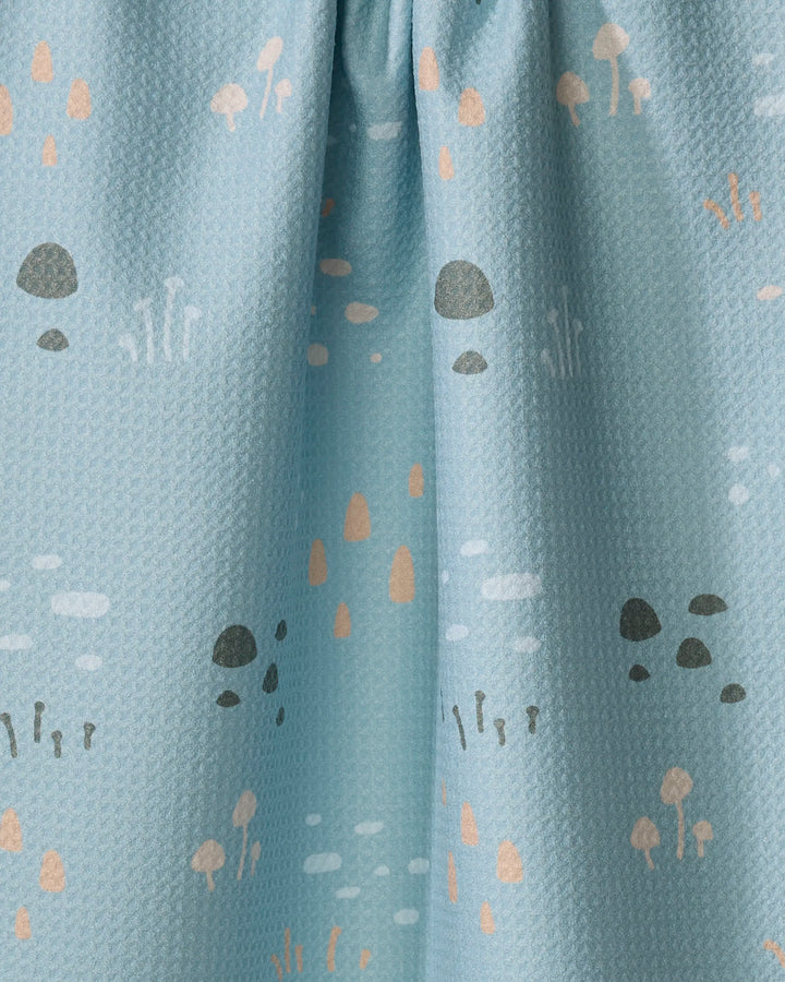 The Amberleigh Adoff Mini Shroom Sprouts towel is a light blue, textured kitchen towel with small gray, beige, and peach mushrooms and plants. Made from recycled materials for an eco-friendly touch.