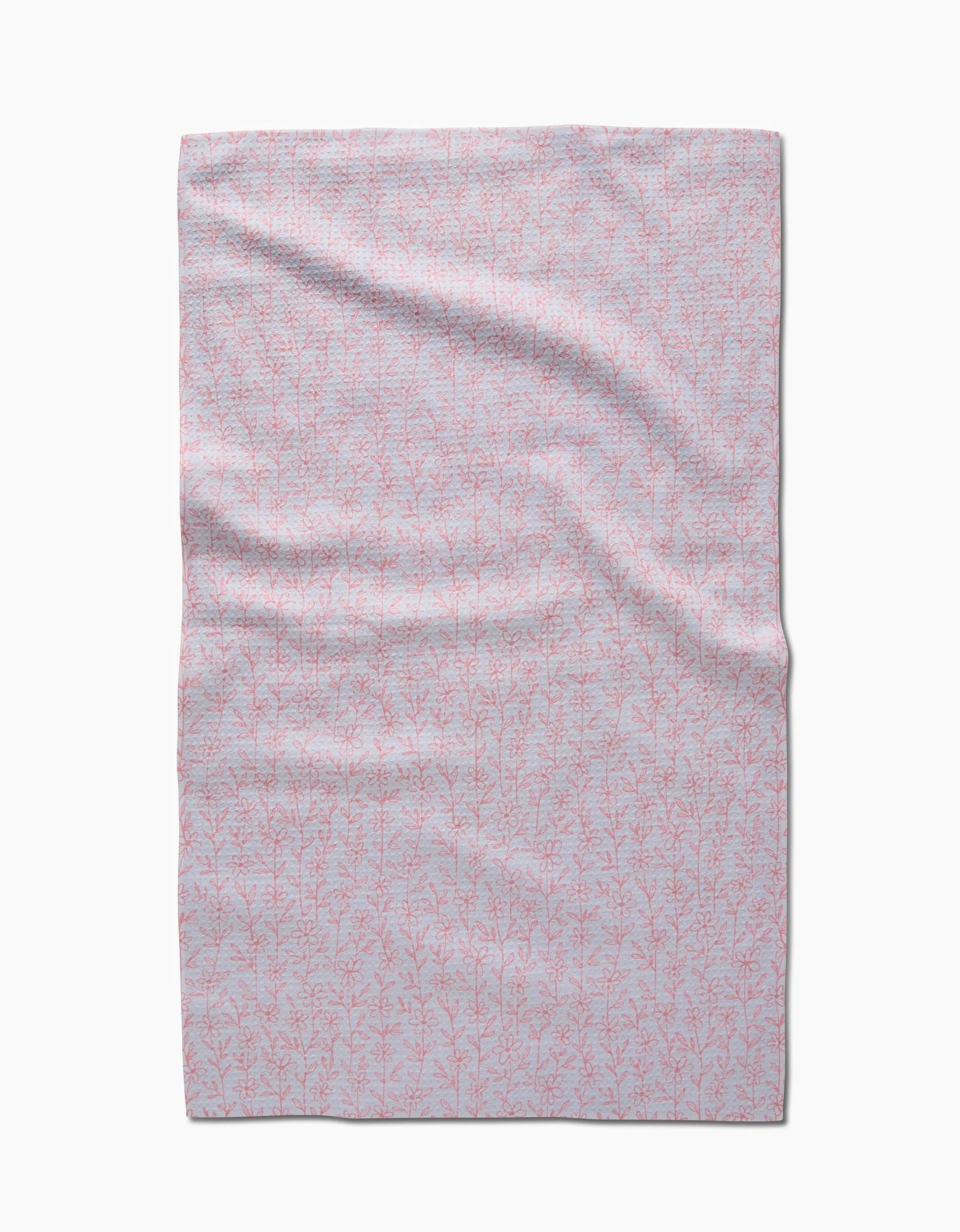 The Minimalist Blush blanket by Teri the Butter, made from light grey Geoweave fabric, features a subtle pattern of delicate pink branches and leaves and is shown laid flat on a white background.
