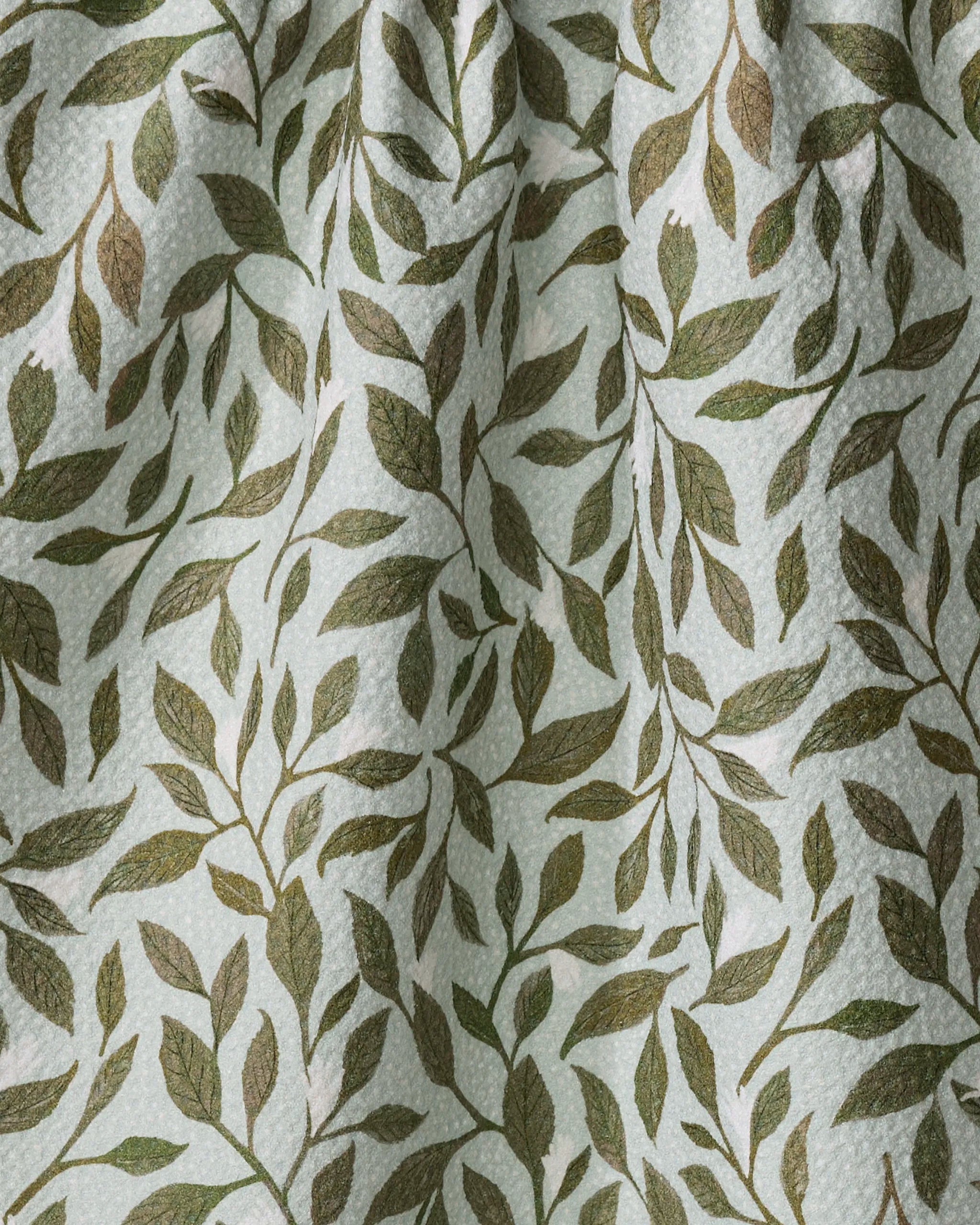 A close-up of the Mint Leaves tea towel by Katie O'Shea. Its light fabric features green and brown leafy branches, visible creases, and texture—ideal as an eco-friendly kitchen towel.