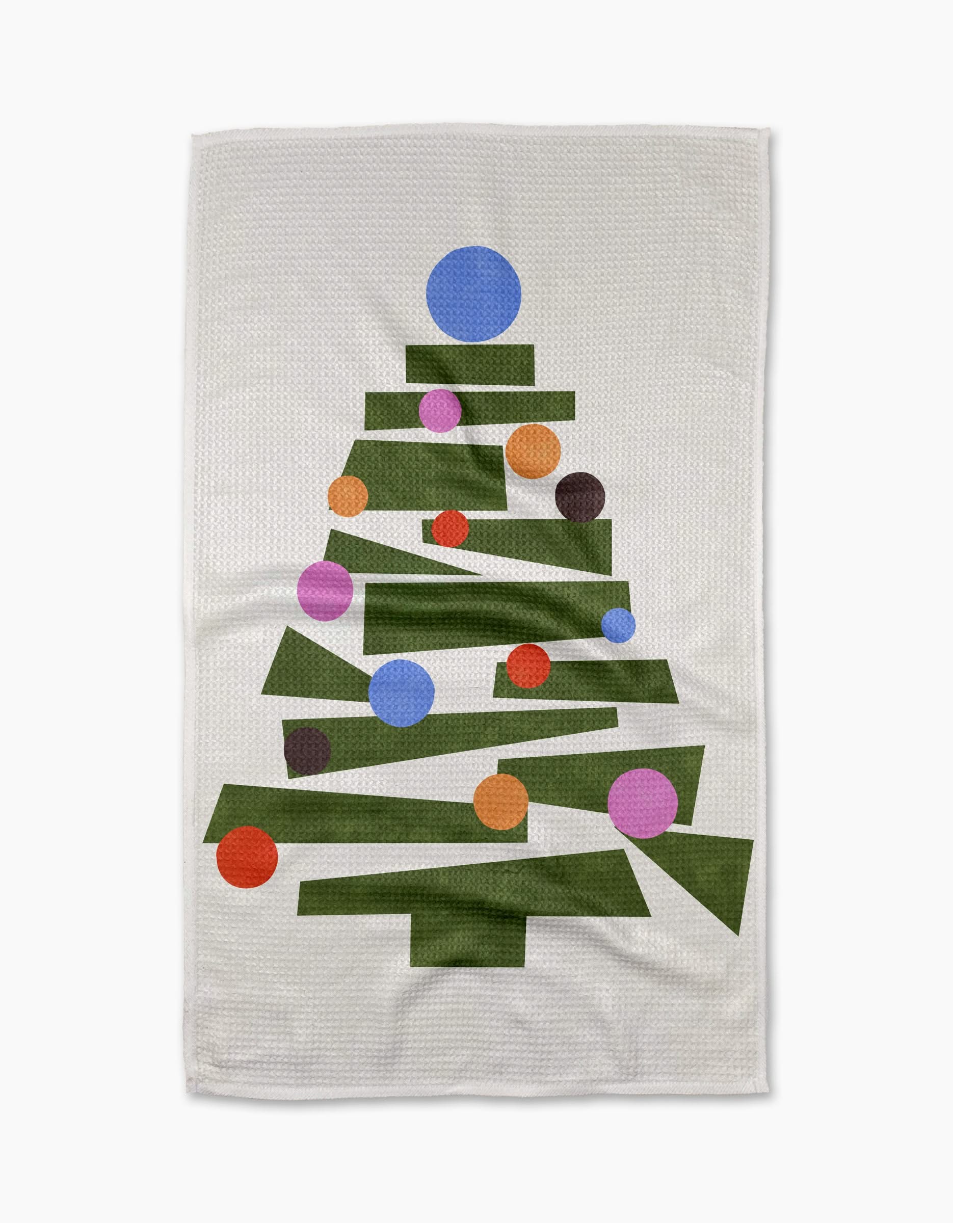The Claire Iglesias Modern Festive Tree tea towel is ultra-absorbent and showcases a white background with a green geometric Christmas tree adorned with colorful red, orange, blue, and purple circles.