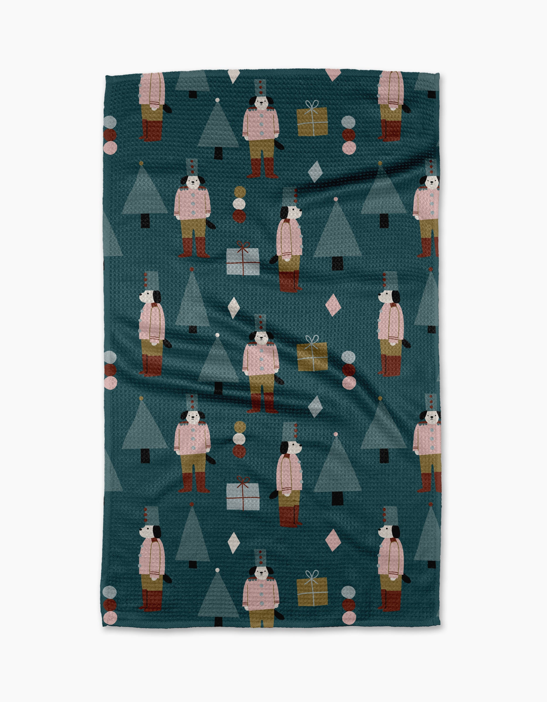 The "Modern Nutcracker" tea towel by Jennifer Bouron features nutcrackers, Christmas trees, gifts, and ornaments on dark teal, crafted from recycled materials for a sustainable holiday accent.