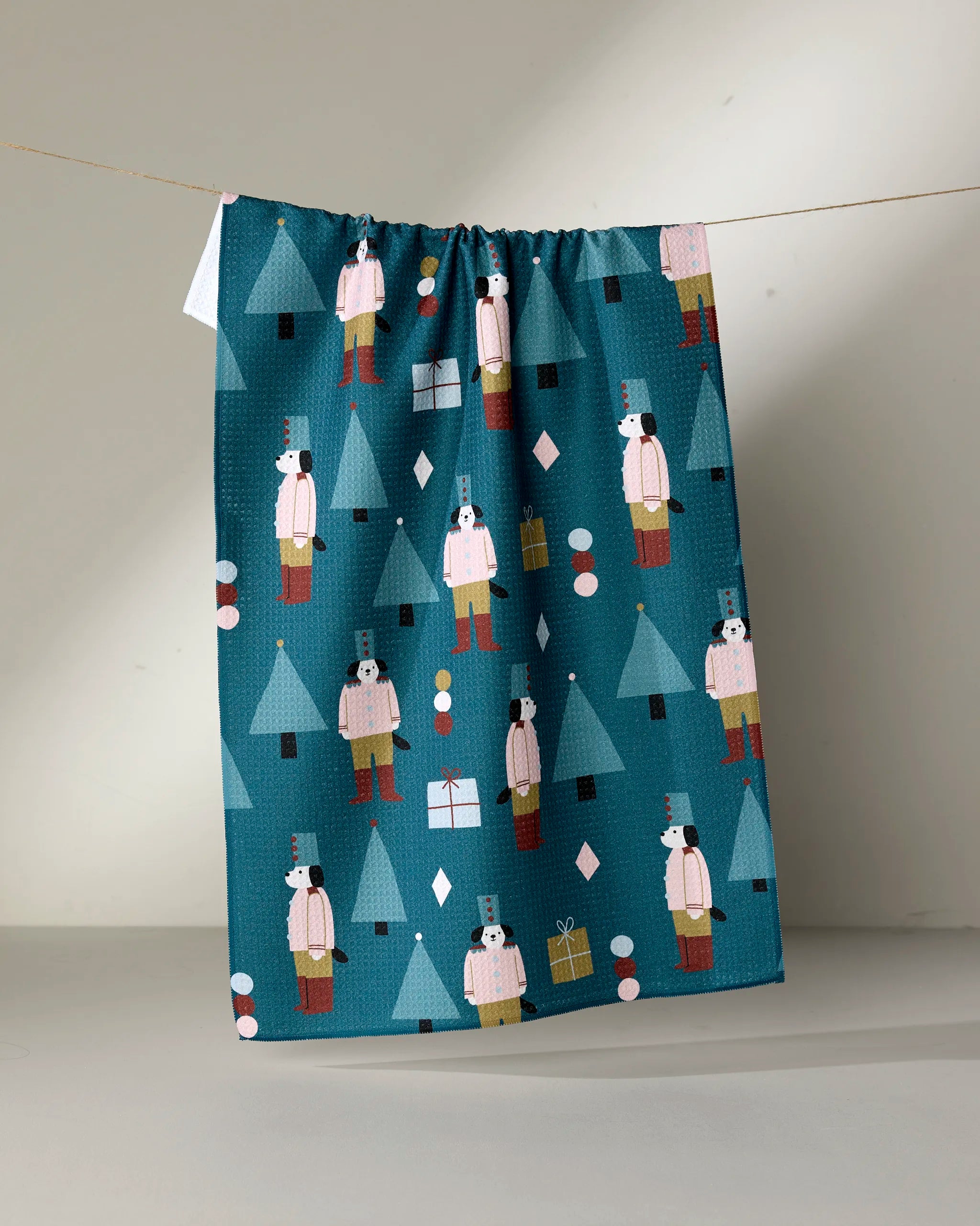 The Jennifer Bouron "Modern Nutcracker" tea towel features festive nutcracker soldiers, Christmas trees, ornaments, and gifts. Add holiday charm to your kitchen and tackle spills easily with this absorbent and stylish dish towel.