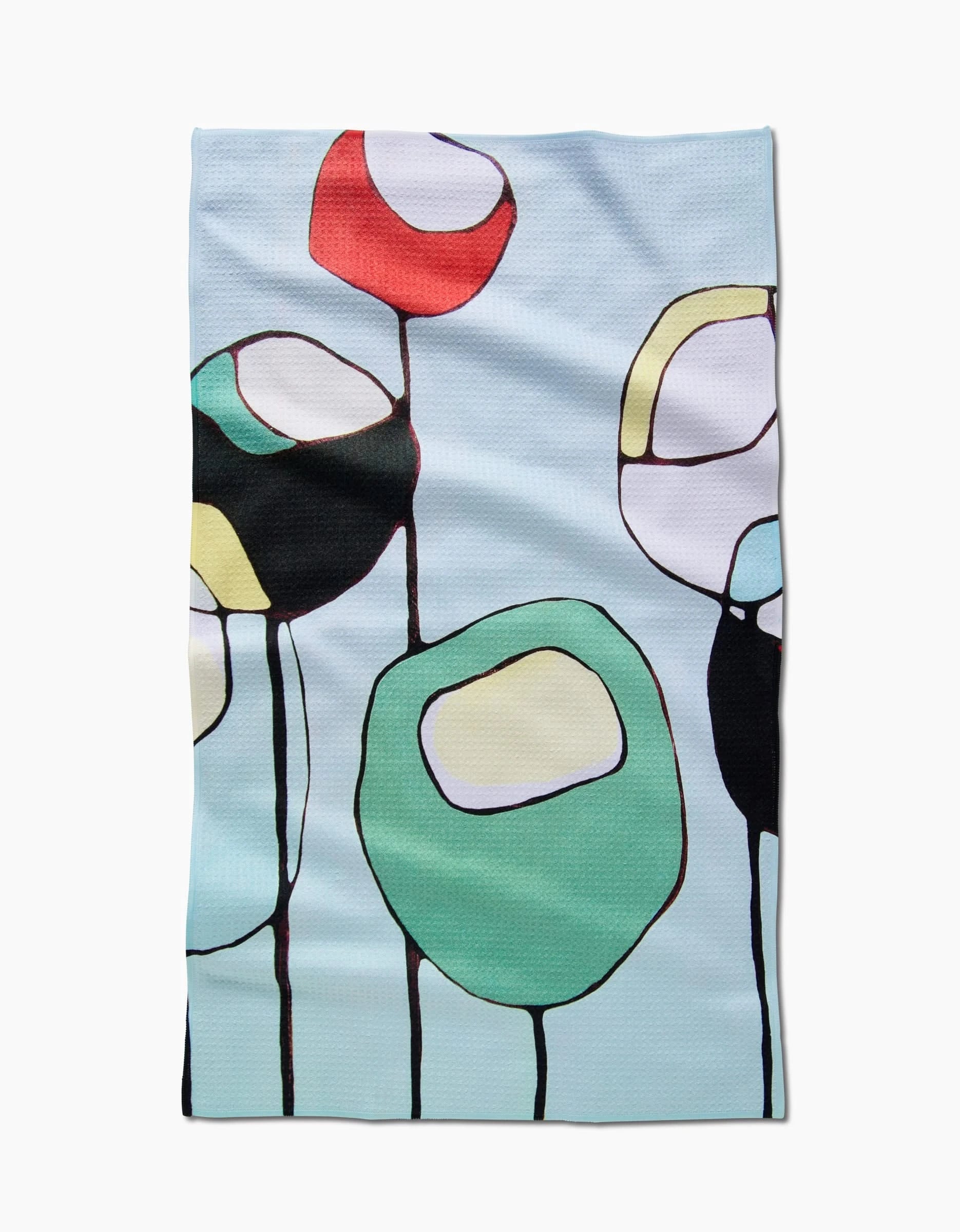 The Modern Poppy tea towel by Rachel Austin features a modern abstract design with large red, green, black, and white circular poppy shapes outlined in black on a light blue background. Made from soft Geoweave fabric.