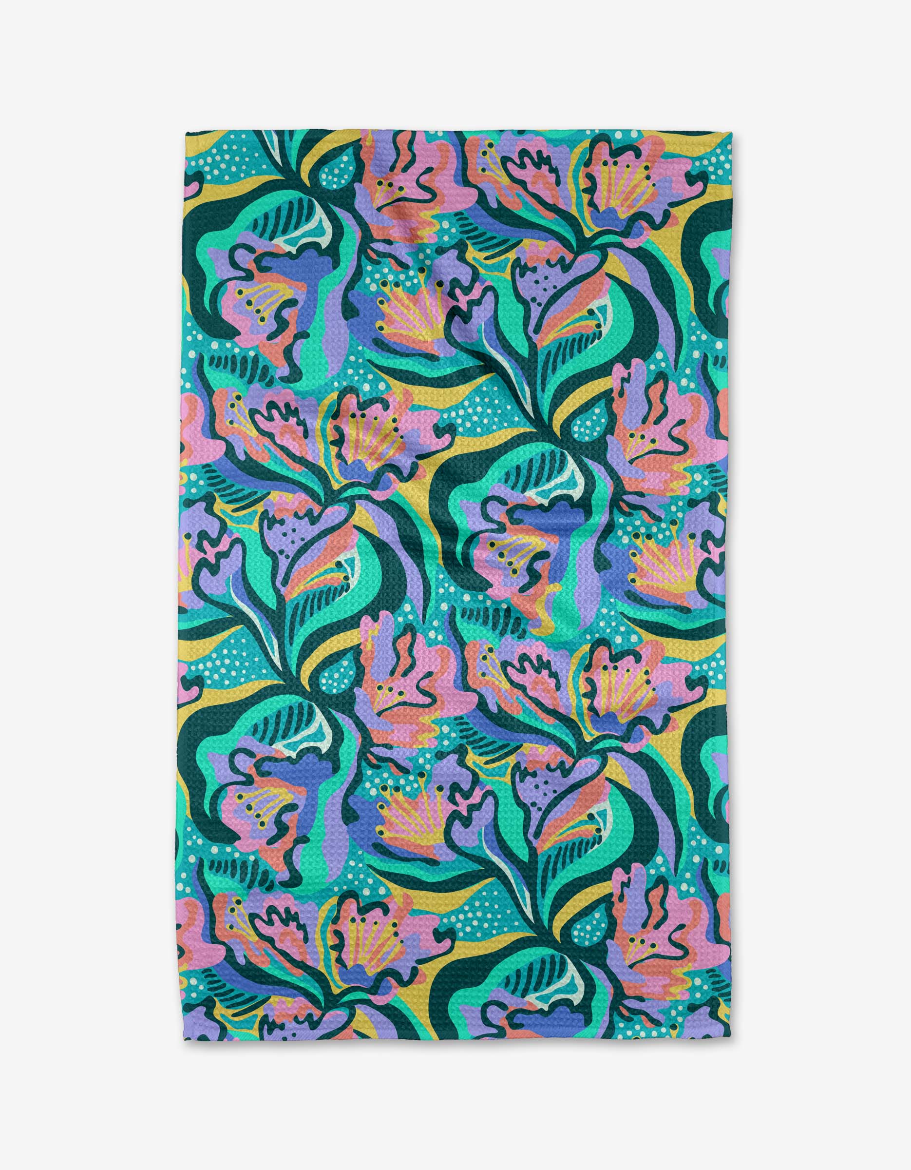 The Moody Flowers tea towel by Masha Volnova features a bold, colorful abstract floral and leaf pattern in green, blue, purple, yellow, and pink on white. Ultra-absorbent and vibrant, the dense design covers the entire rectangular towel.