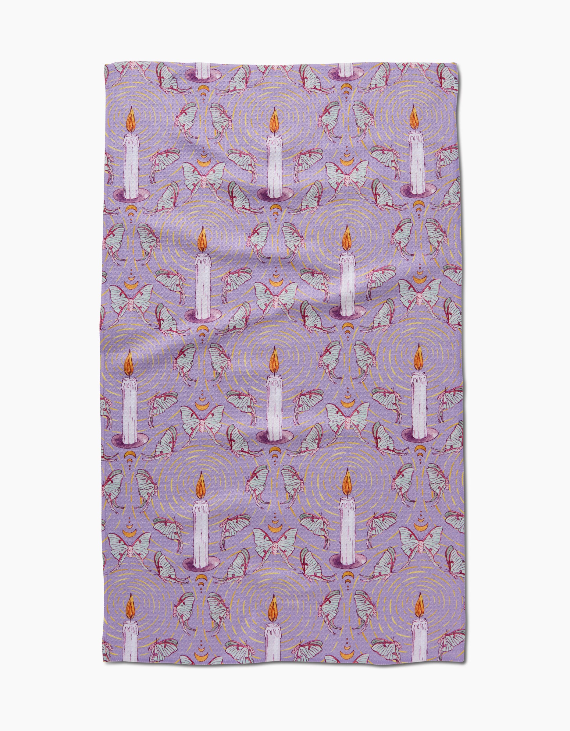 The Moth To A Flame tea towel by Maayan Alper-Swan features white candles with orange flames, hands, and small eyes on a lavender background. Made from recycled materials, it boasts subtle decorative details throughout.