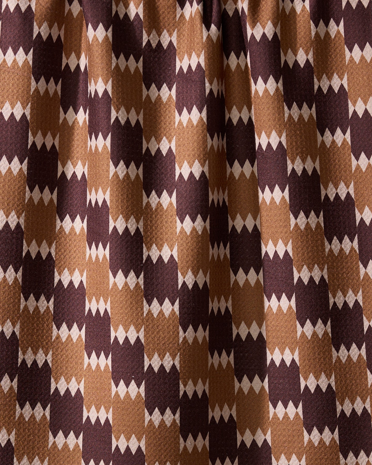 The Geometry Mountain Song recycled kitchen towel features a visually dynamic geometric pattern with alternating brown, tan, and beige diamond shapes in vertical rows.