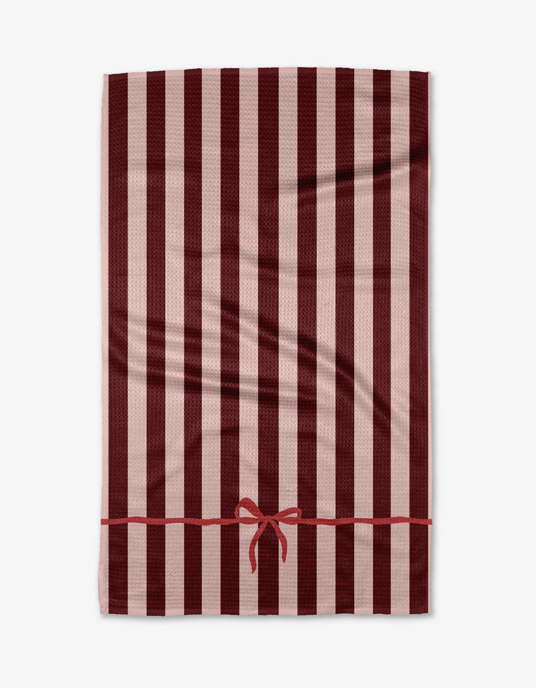 The Mrs. Clause kitchen towel by Kelsi Fullmer features vertical maroon and light pink stripes with a horizontal maroon ribbon and bow near the bottom, shown on a white background.