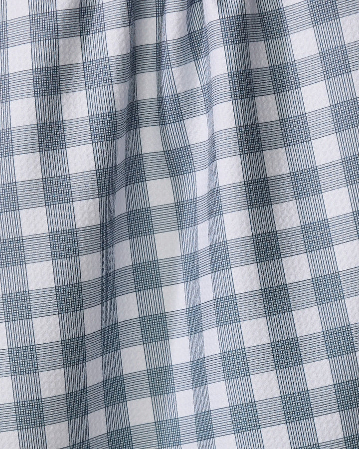 A close-up of The Buy Guide's Multi Gingham - Navy tea towel, featuring a white base with a navy checkered pattern and visible woven texture. The fabric is softly gathered, creating gentle folds and shadows.