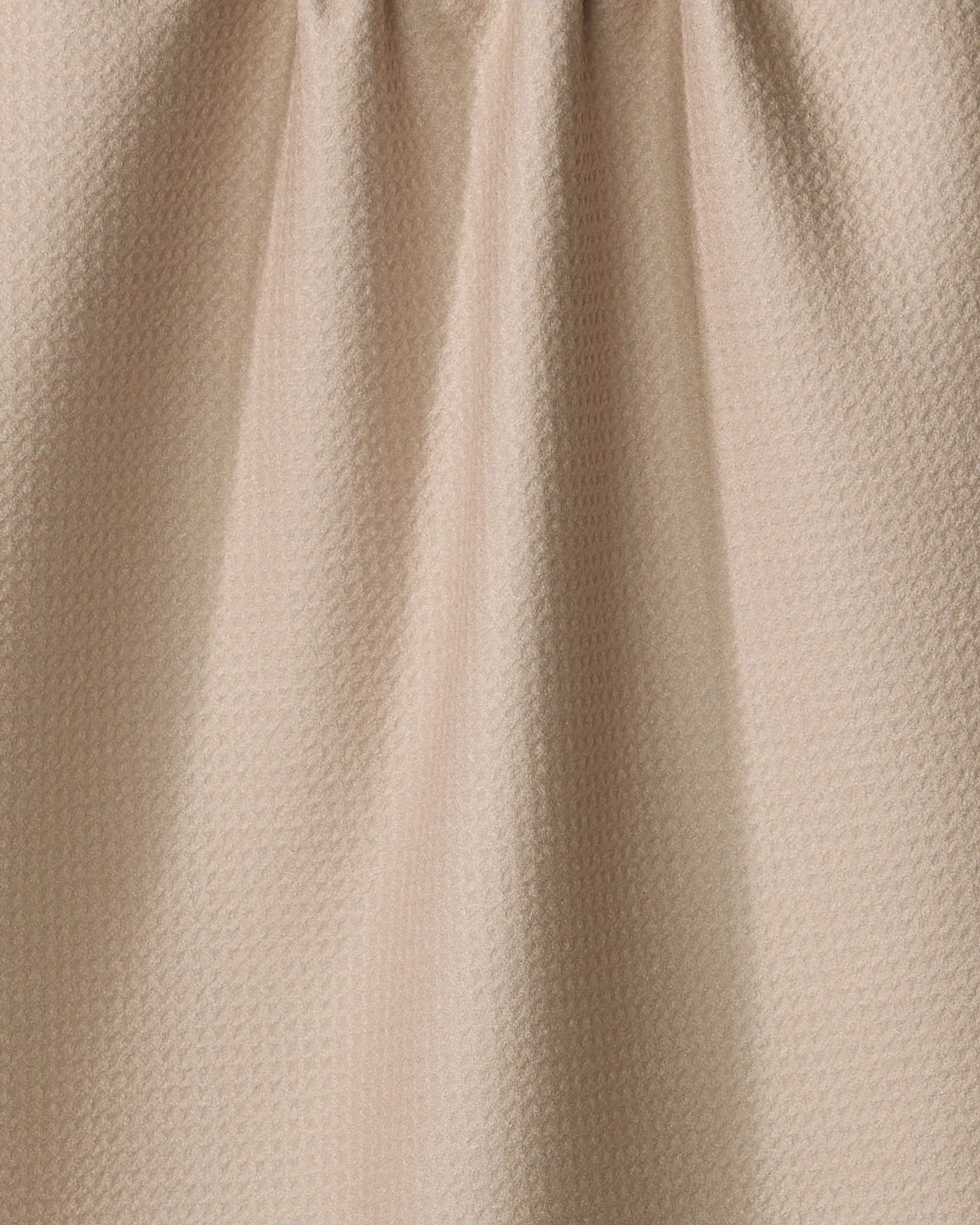 Close-up of “My Happy Place” by Kelsi Fullmer: an eco-friendly, light beige textured fabric with small geometric patterns and soft vertical folds—perfect for a stylish kitchen towel.