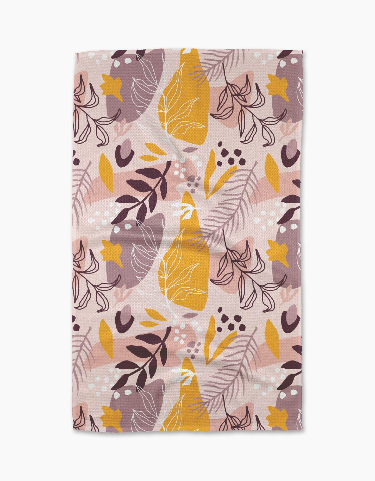 The Cottonflower Studio Nature Sketch tea towel is a rectangular, ultra-absorbent dish towel with an abstract botanical pattern of leaves, berries, and broad shapes in yellow, white, brown, and mauve on pale pink.