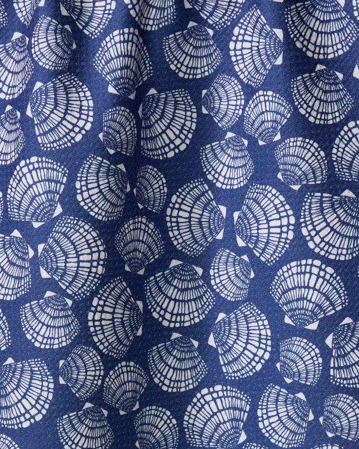 A close-up of Kris Ruff's Nautical Seashells fabric shows blue material with white seashells in various orientations and intricate line details, resembling a quick-drying towel.