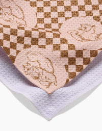 Aubrey Fairchilds Nuts About You tea towel features playful squirrel illustrations on pink and brown checks, layered over white textured cloth. Made from recycled materials, this quick-drying towel brings eco-friendly charm to your kitchen.