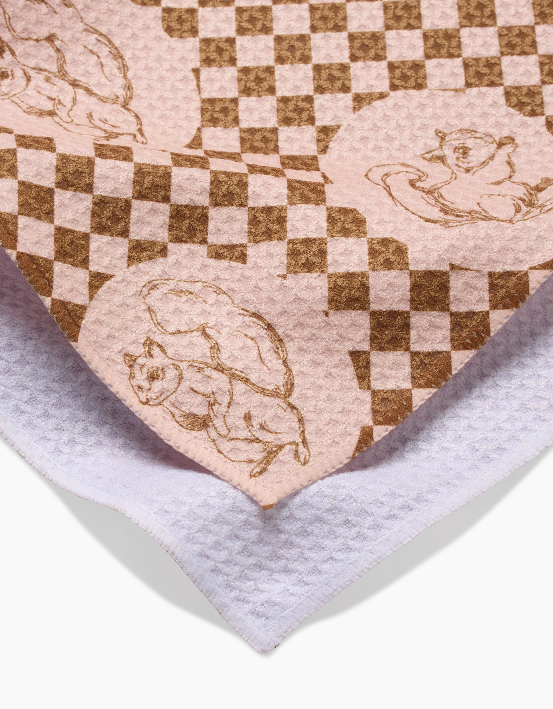Aubrey Fairchilds Nuts About You tea towel features playful squirrel illustrations on pink and brown checks, layered over white textured cloth. Made from recycled materials, this quick-drying towel brings eco-friendly charm to your kitchen.