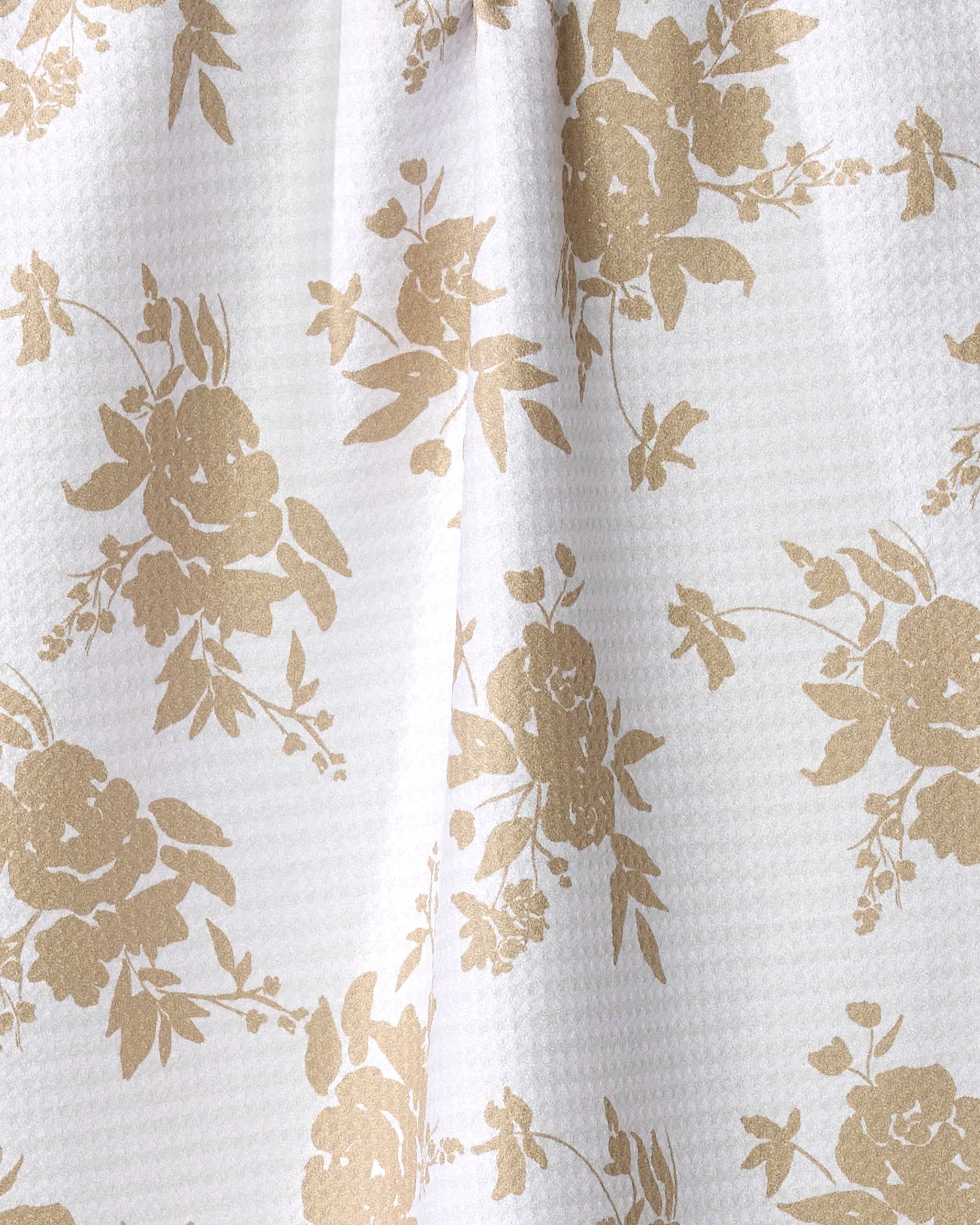 Oatmeal Floral by Aubrey Fairchild features a white textured fabric with a repeating light brown rose and leaf pattern. Made from quick-drying material, it drapes softly, creating gentle folds.