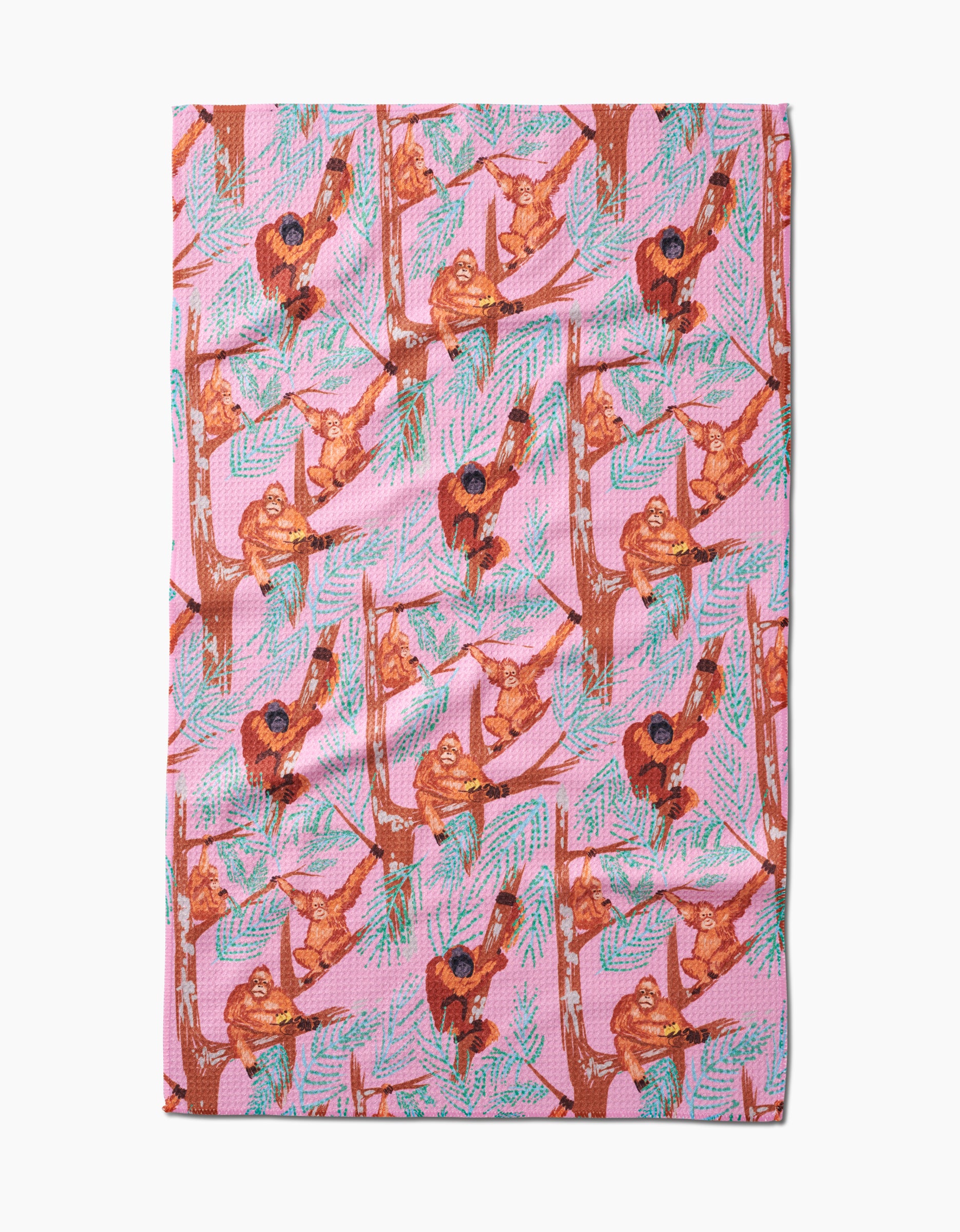 The Orangutan Clan tea towel by Elisabeth Wing features illustrated orangutans on tree branches with green leaves, printed on soft Geoweave fabric made from recycled materials.