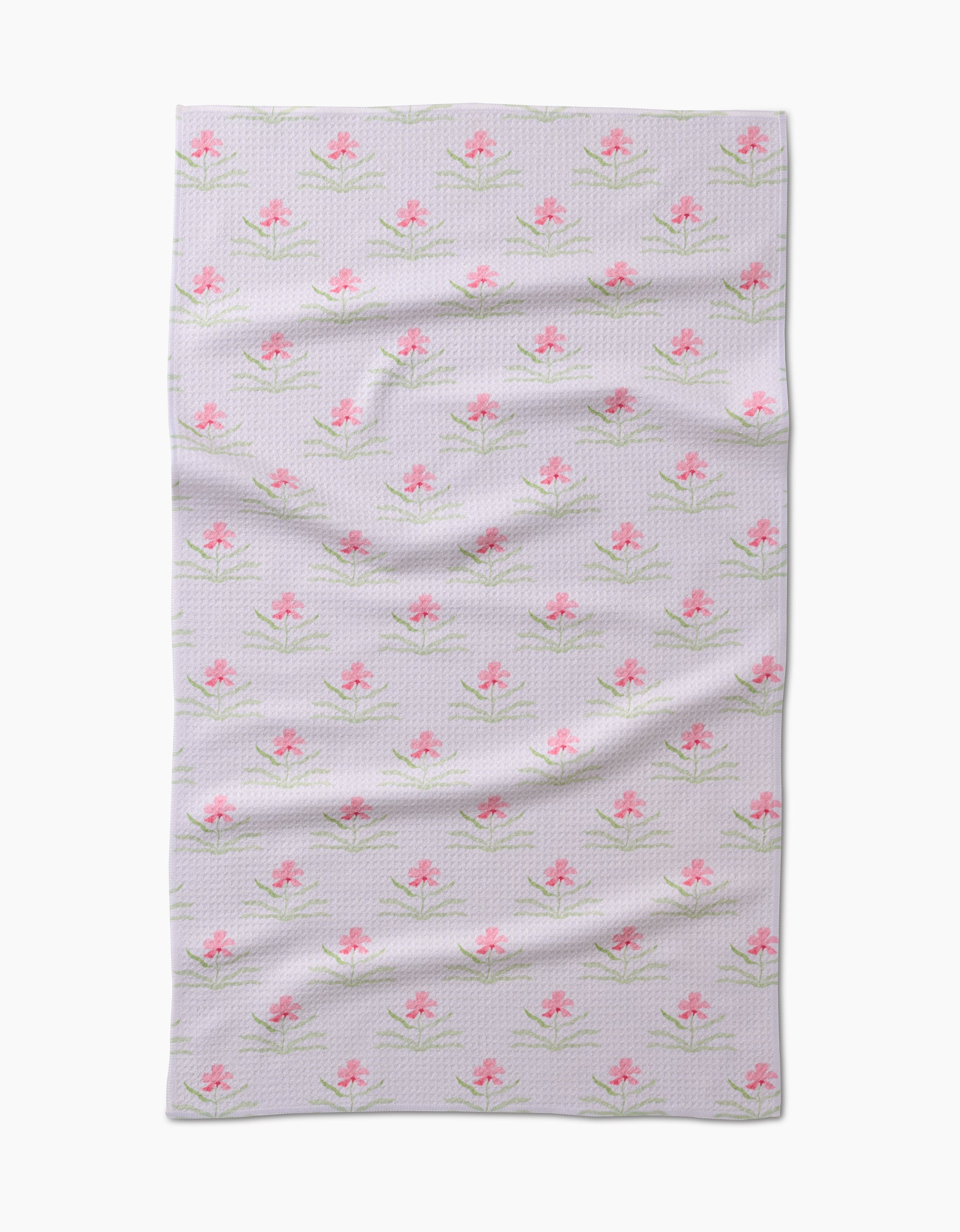 The Orchids In Bloom Tea Towel by Laura Prietto is a light-colored, rectangular Geoweave towel with a pink flower and green leaf pattern, shown flat with visible folds and creases.