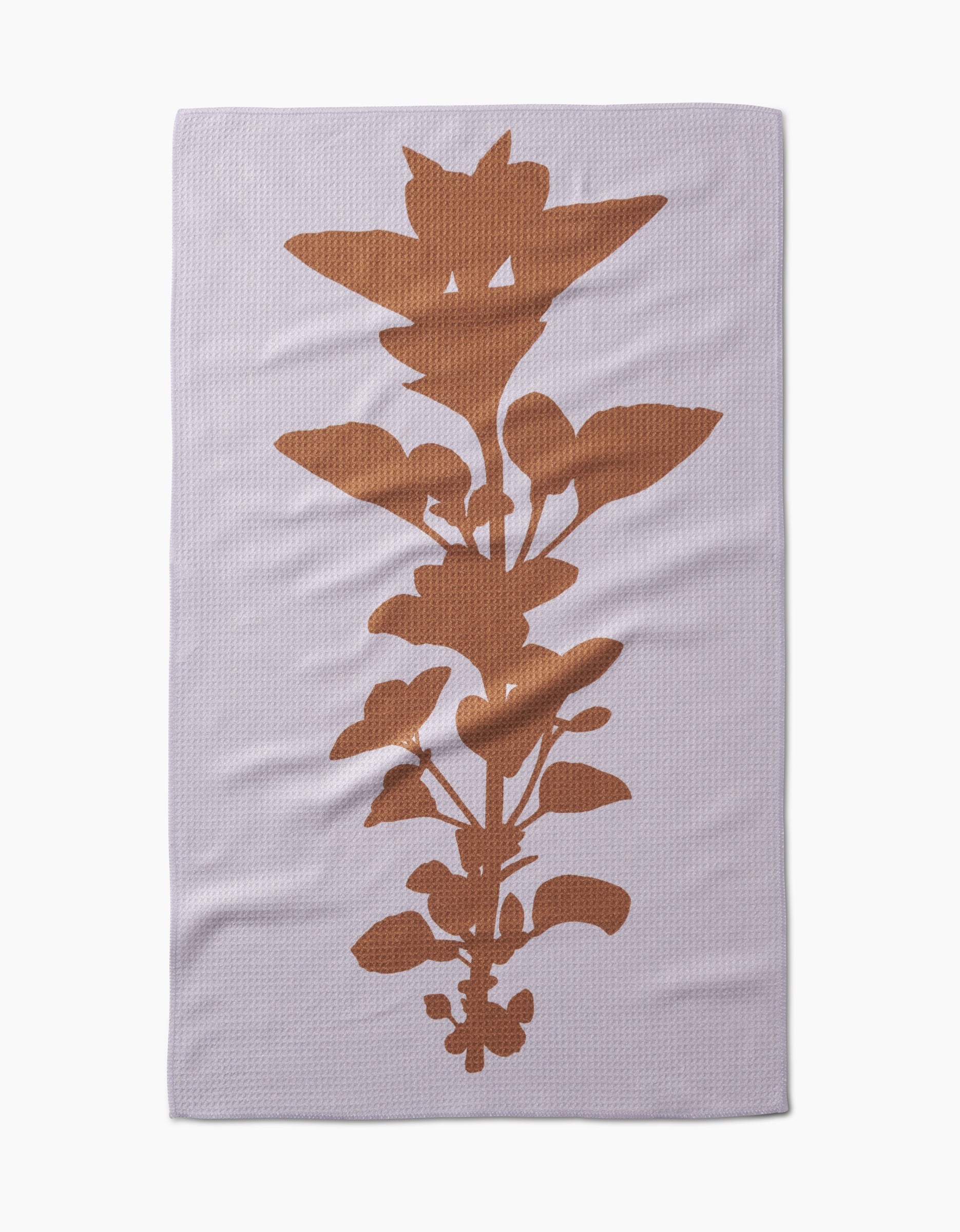 The PrintedPlant Oregano Tea Towel is pale lavender with a large, rust-colored oregano silhouette centered vertically, and is crafted from recycled materials.