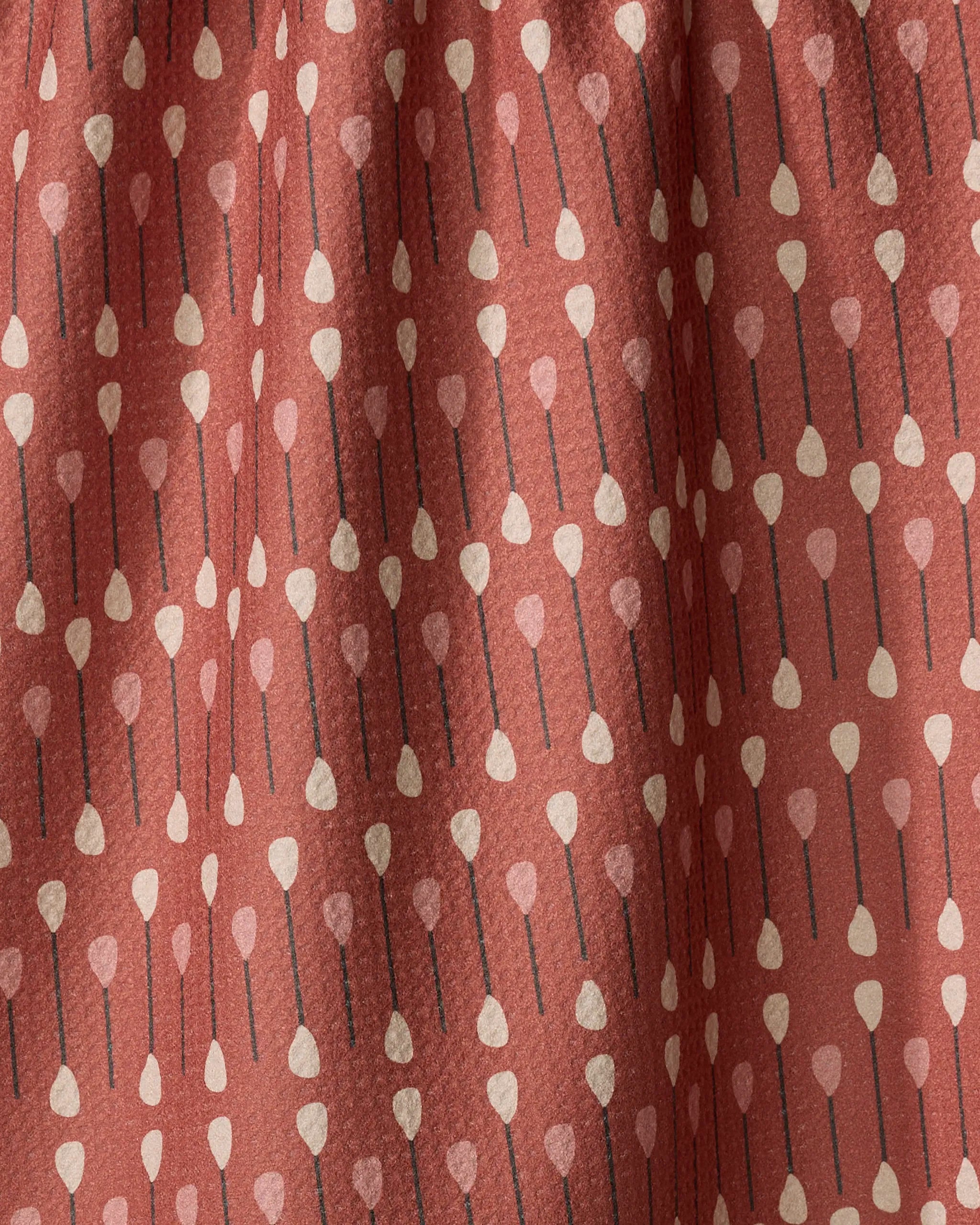 The Coit Creative "Paddles and Oars" tea towel features a rust color and vertical rows of stylized paddles with beige tips, black shafts, and light pink heart-shaped ends. Made from quick-drying recycled materials and shown with gentle folds.