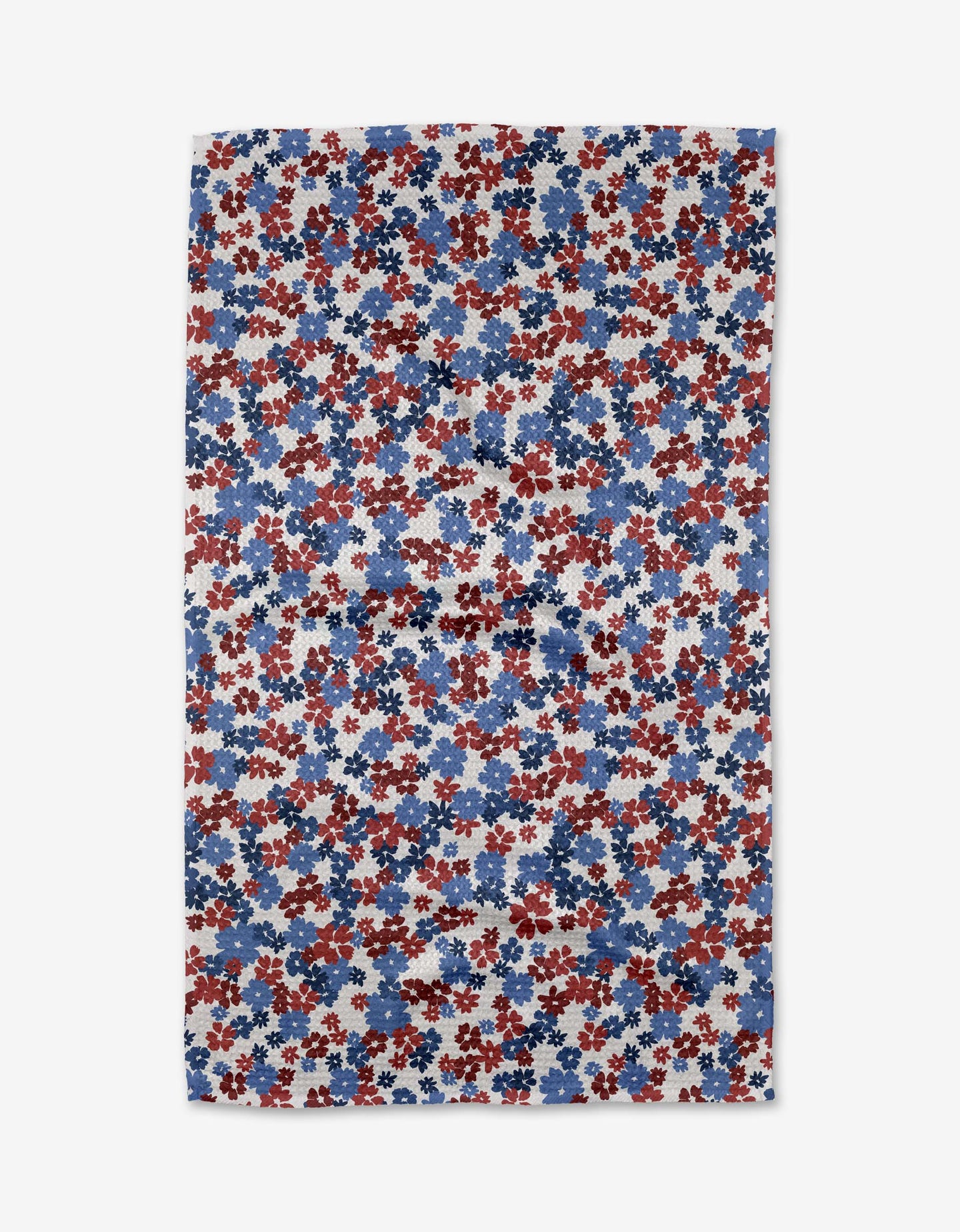 The Painted Petals Kitchen Tea Towel by Ashley Celena features a rectangular Geoweave fabric with a dense floral pattern of red, white, and blue flowers on a light background, viewed from above.