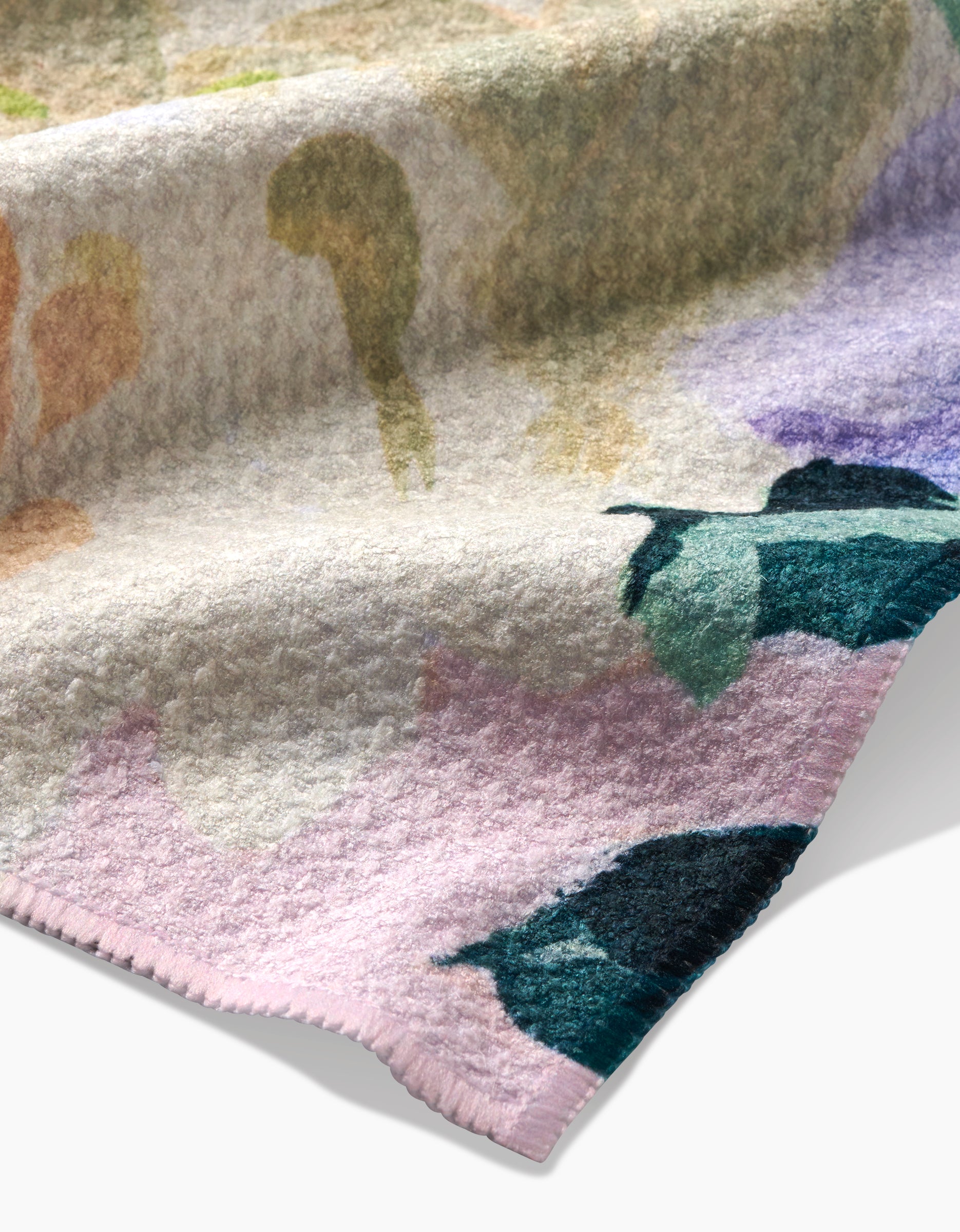 A close-up of Ania Zwara Arts Pastel Bouquet blanket, crafted from recycled materials with a soft texture, pastel floral pattern in green, purple, pink, and cream, and detailed edge stitching.