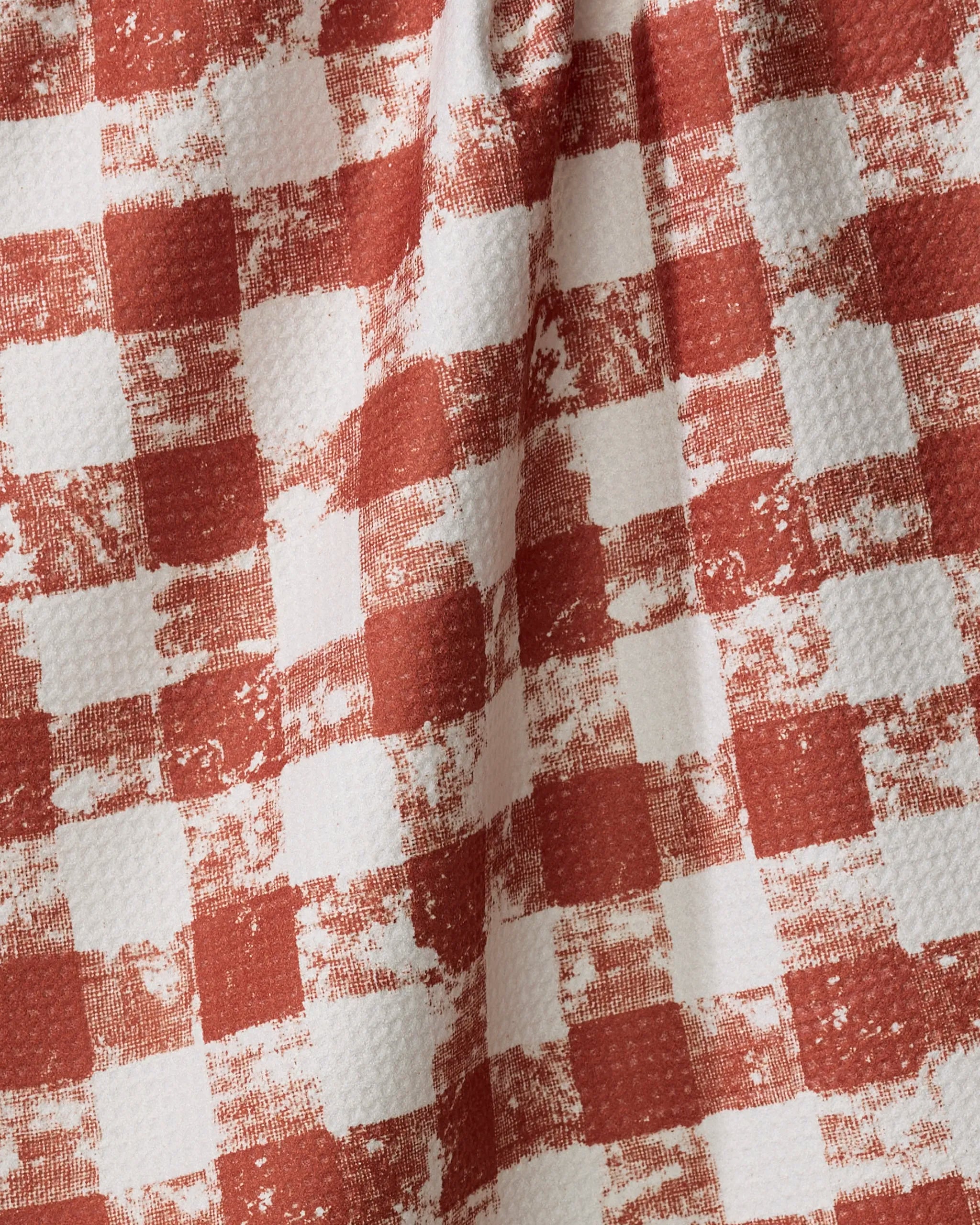 The Geometry Patch Spice tea towel features a red and white checkered design with a textured, vintage-inspired finish. Its slightly wrinkled look and uneven, faded checks add charm to your kitchen essentials.