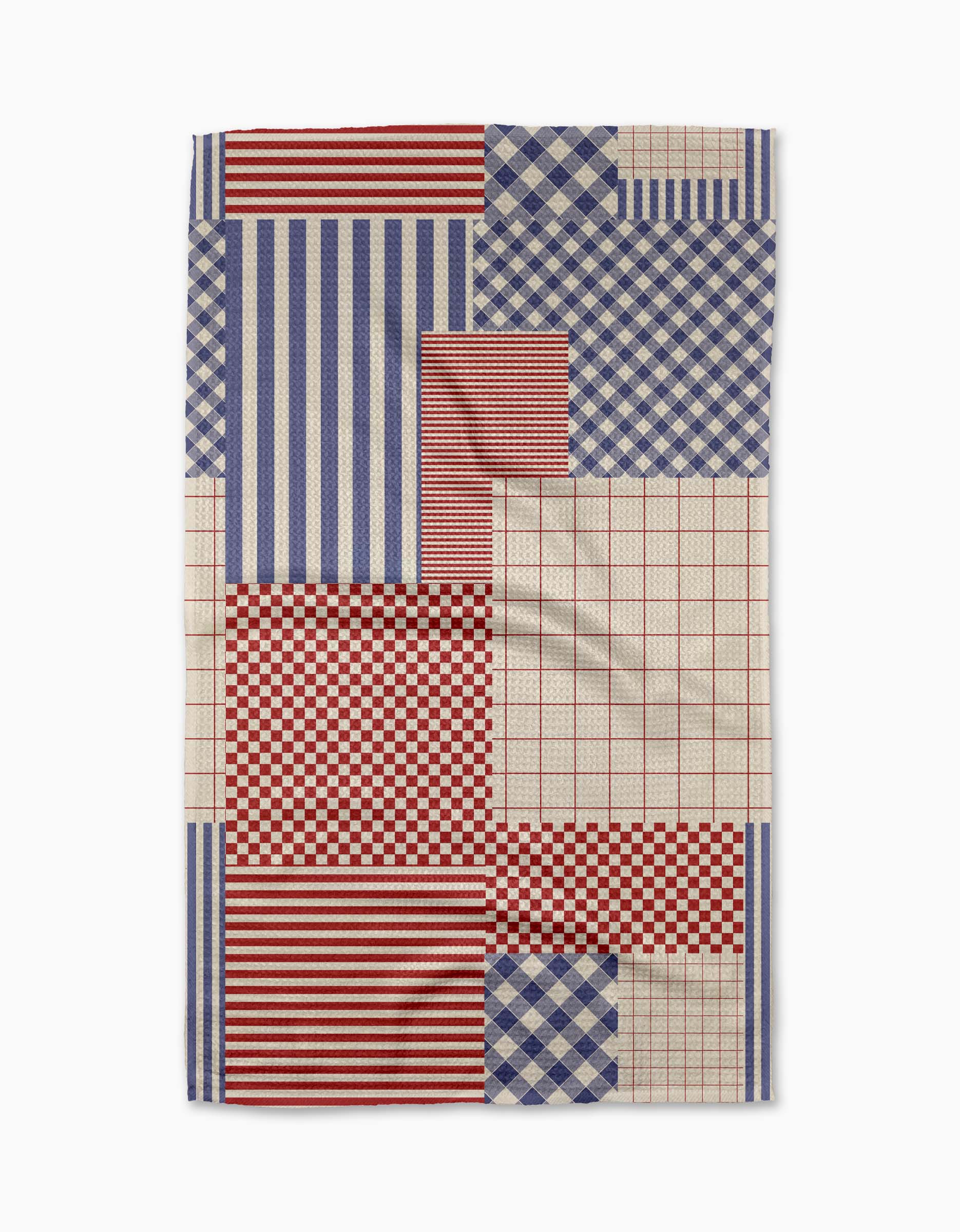 The Patched Up Parade tea towel by Geometry features a rectangular design with red, blue, and beige patchwork—stripes, checks, and plaid—in geometric sections. Made from recycled materials, the fabric has a slightly wrinkled look.
