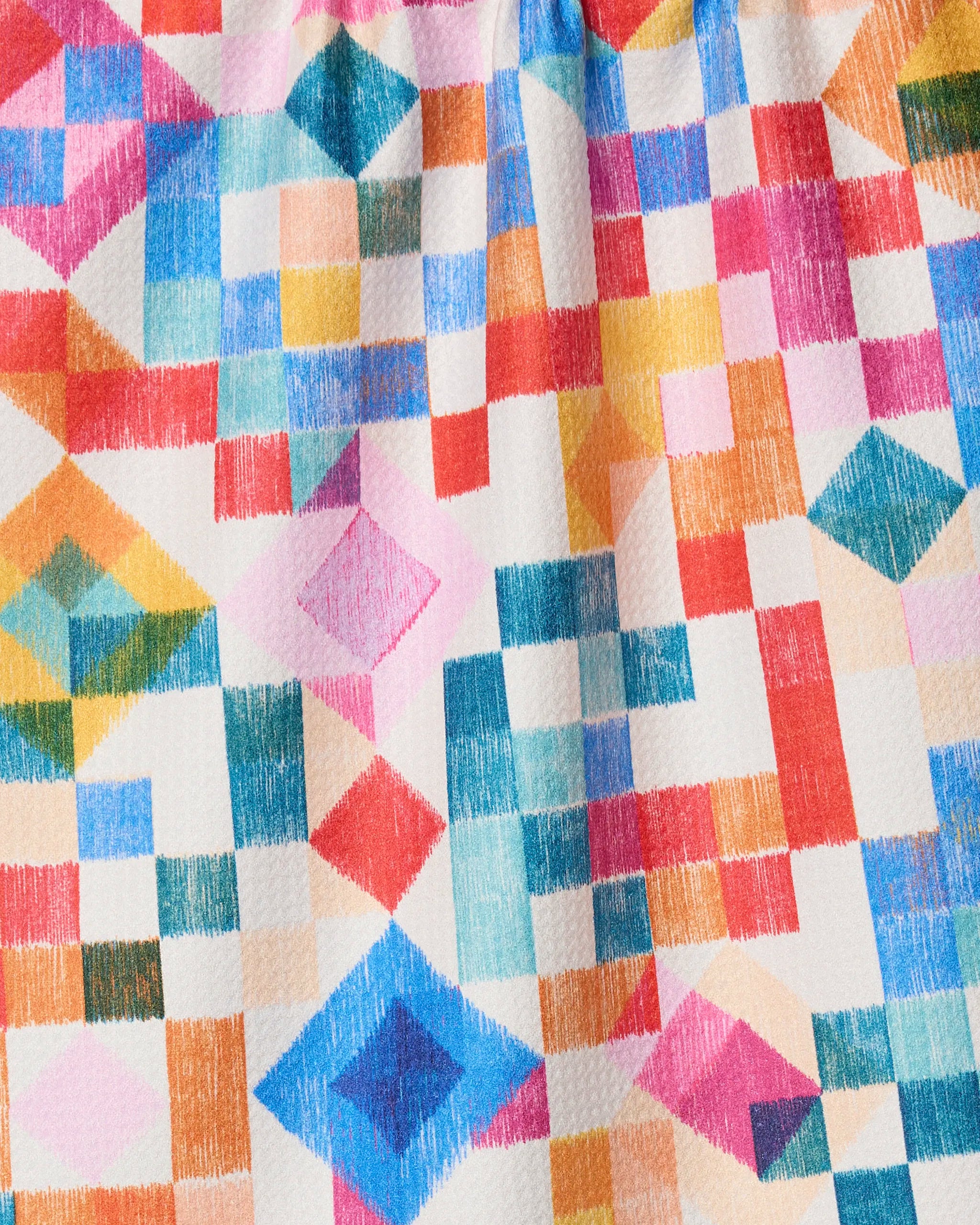 The Patchwork Geo tea towel by Rachel Parker features a colorful square pattern and is made from quick-drying recycled materials.