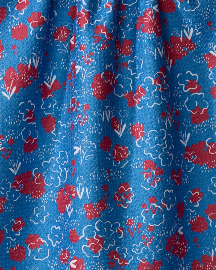 The Second Nature Studio "Patriotic Garden" towel features a soft blue fabric with red and white floral clusters, gentle folds, scattered dots, and an ultra-absorbent, textured finish.