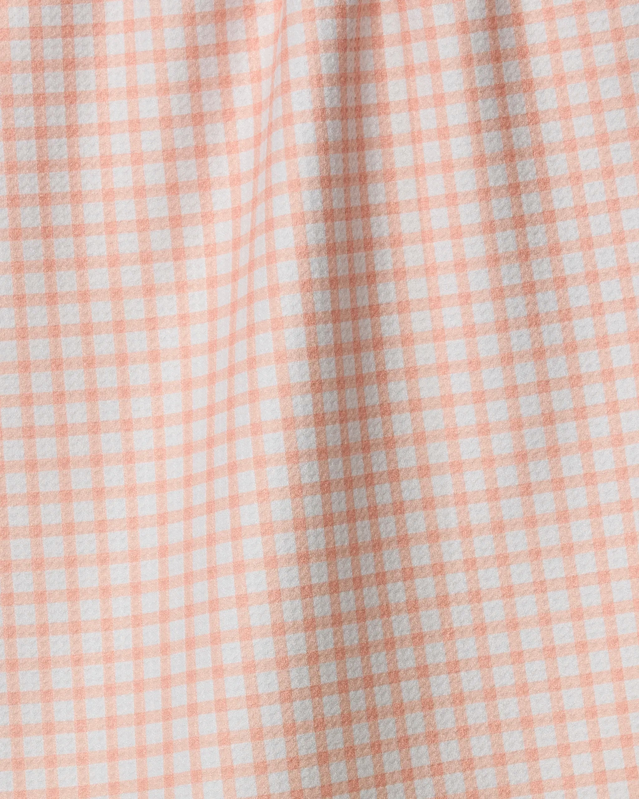 A close-up of Peach Darling by Geometry shows its pink and white gingham checks, softly gathered—an eco-friendly fabric ideal for a chic tea towel in your kitchen.