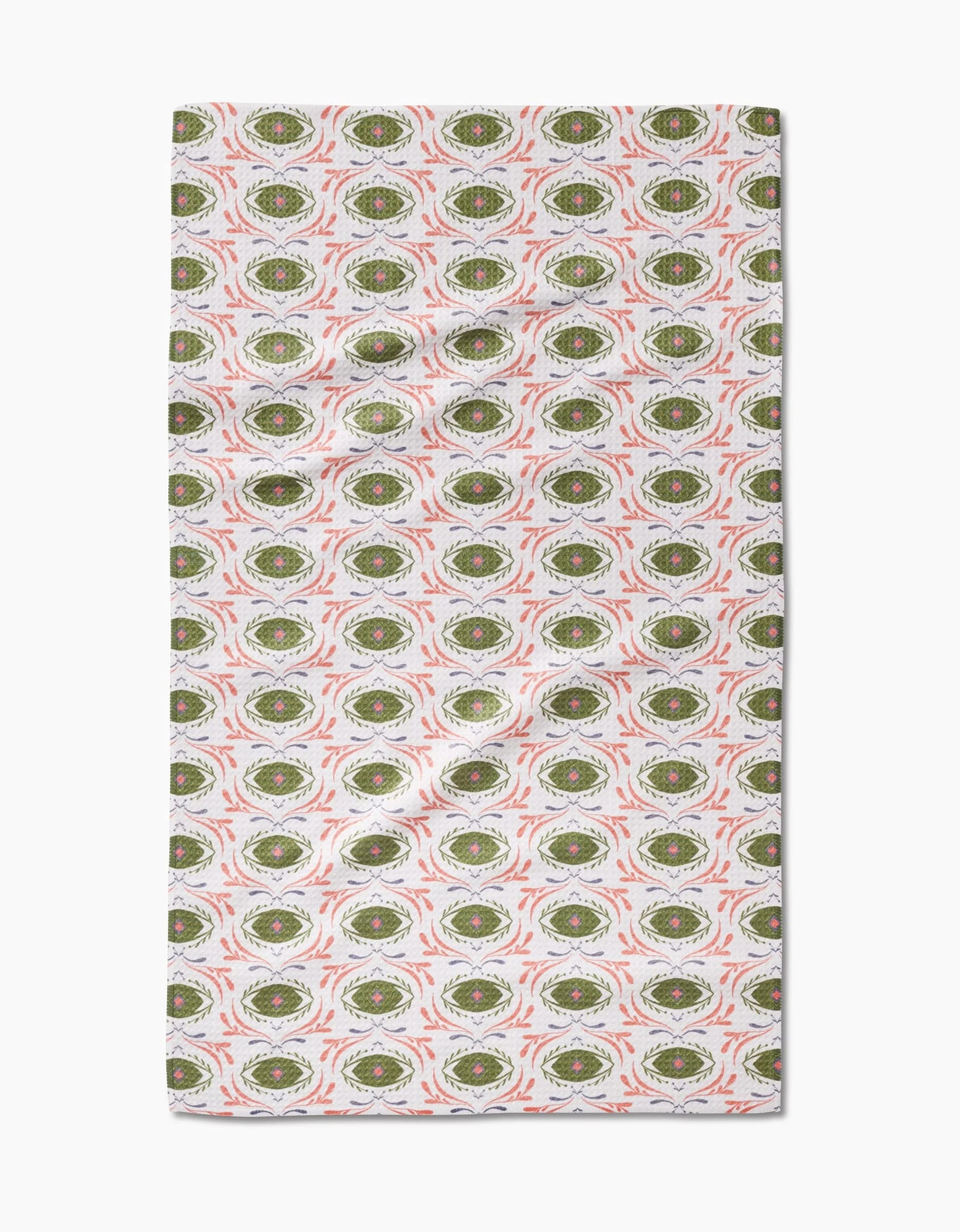 Peacock Eyes tea towel by Amita Nair features a repeating green and white oval pattern with red accents on a light background. This absorbent, quick-drying towel is slightly wrinkled and perfect for everyday kitchen use.