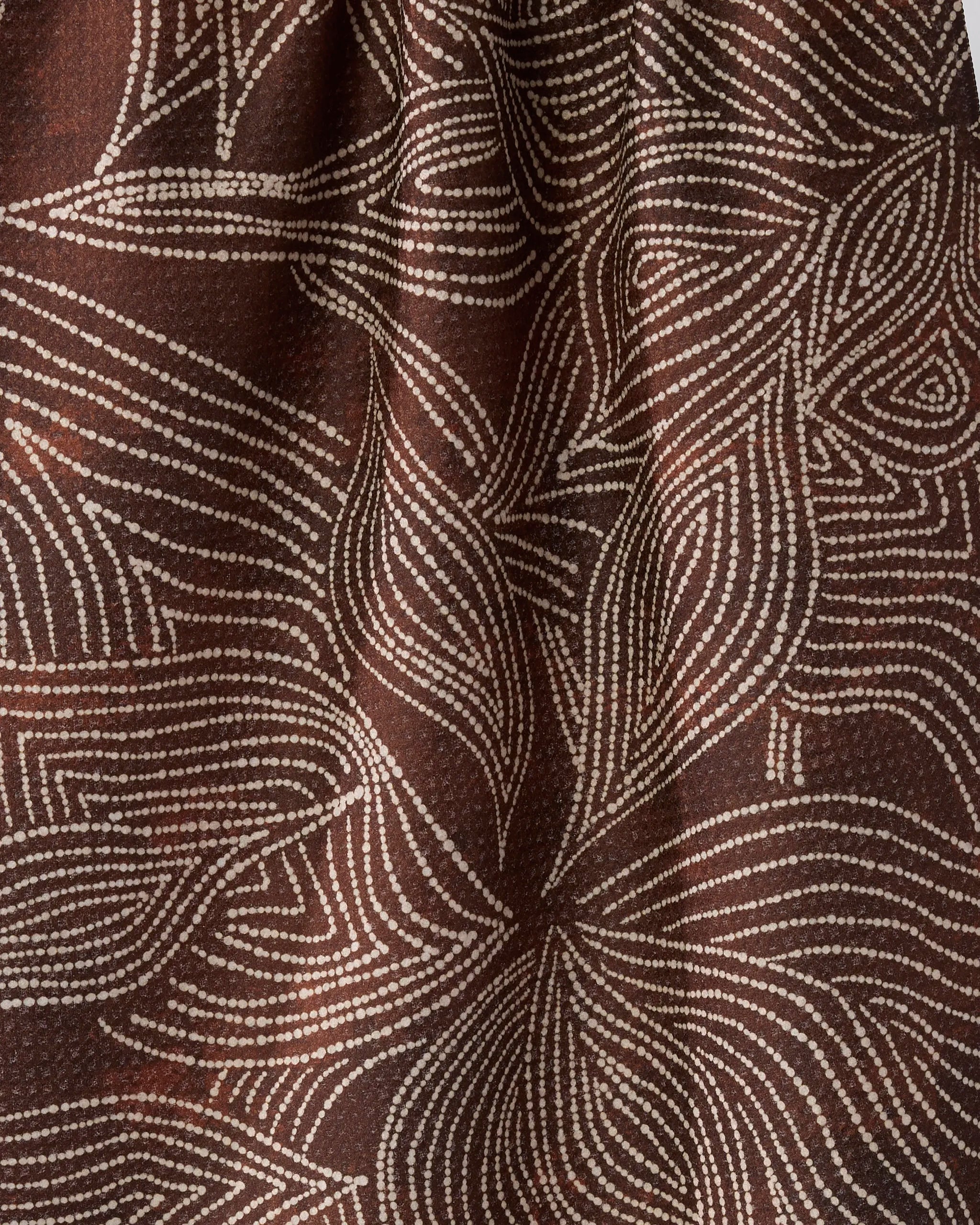 Close-up of Geometry’s Pearl Botanical towel, featuring dark brown, quick-drying fabric adorned with flowing white dotted lines in an organic, leaf-inspired pattern.